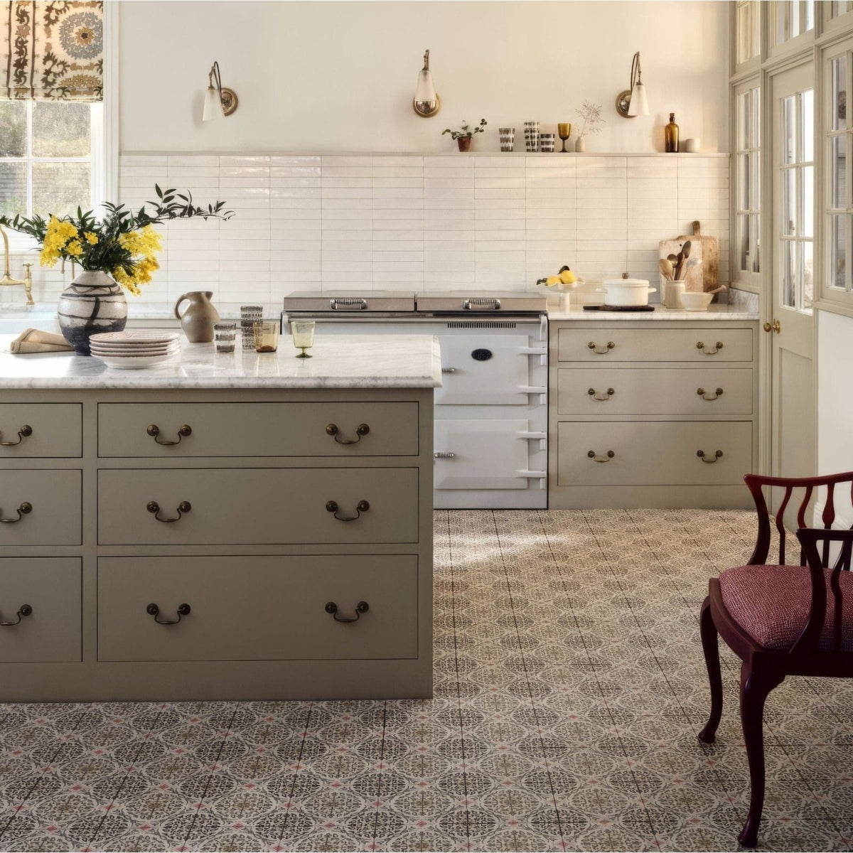White vintage-style aga range cooker with brass handles and knobs featured in nina campbell la moulade chocolate porcelain tile setting