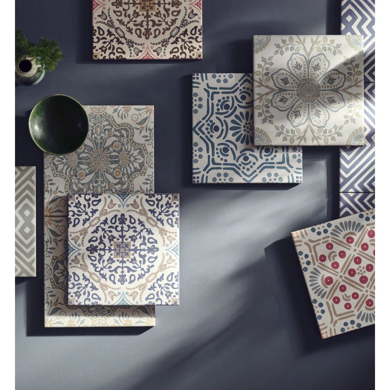 Square porcelain tile with intricate floral and geometric patterns in muted blues gray beige and red by Nina Campbell