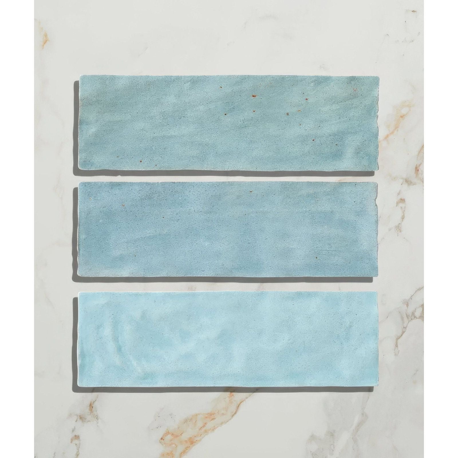 Three rectangular turquoise ceramic tiles with a matte slightly textured finish from oasis ceramic aqua gloss collection