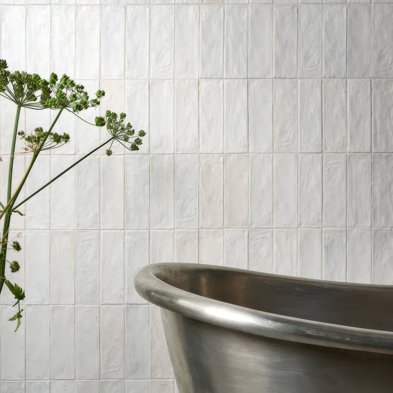 A sleek metallic bathtub with polished silver finish and smooth rounded edges from oasis veloute ceramic white matt