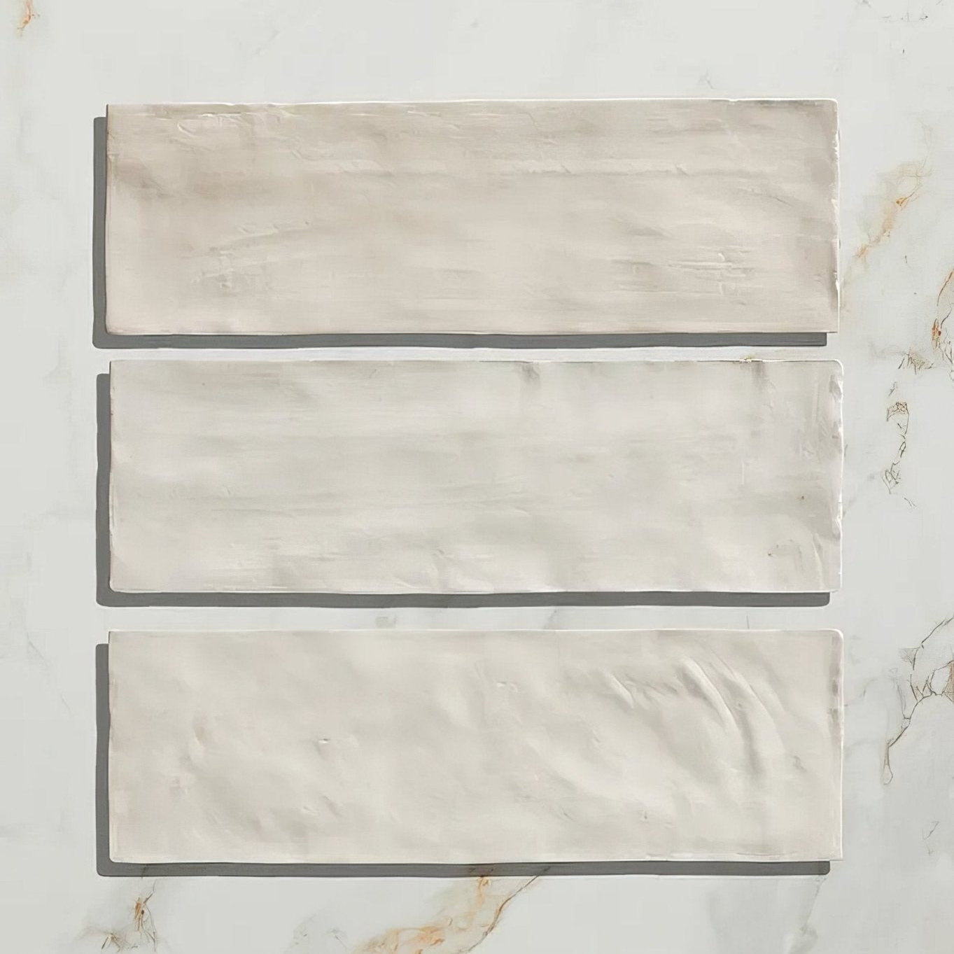 Three rectangular off-white ceramic tiles with textured matte finish from oasis veloute ceramic white matt collection