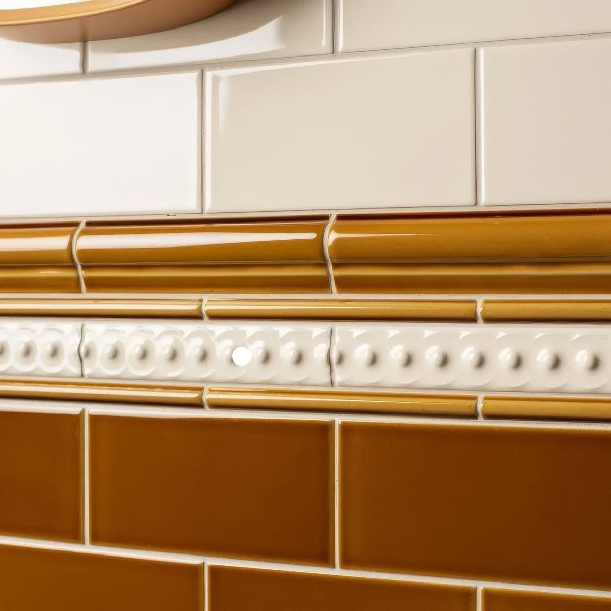 Ceramic tile border ochre omega moulding with glossy amber finish and white decorative bead accents