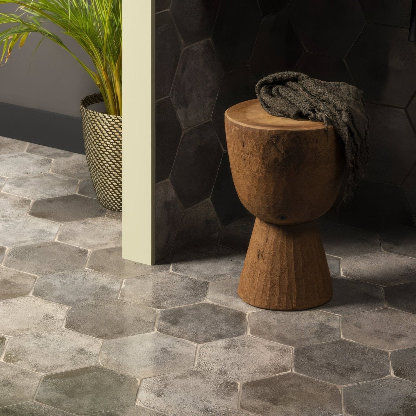 A rustic oken hexagon anthracite wooden stool with hand-carved rounded top and tapered base