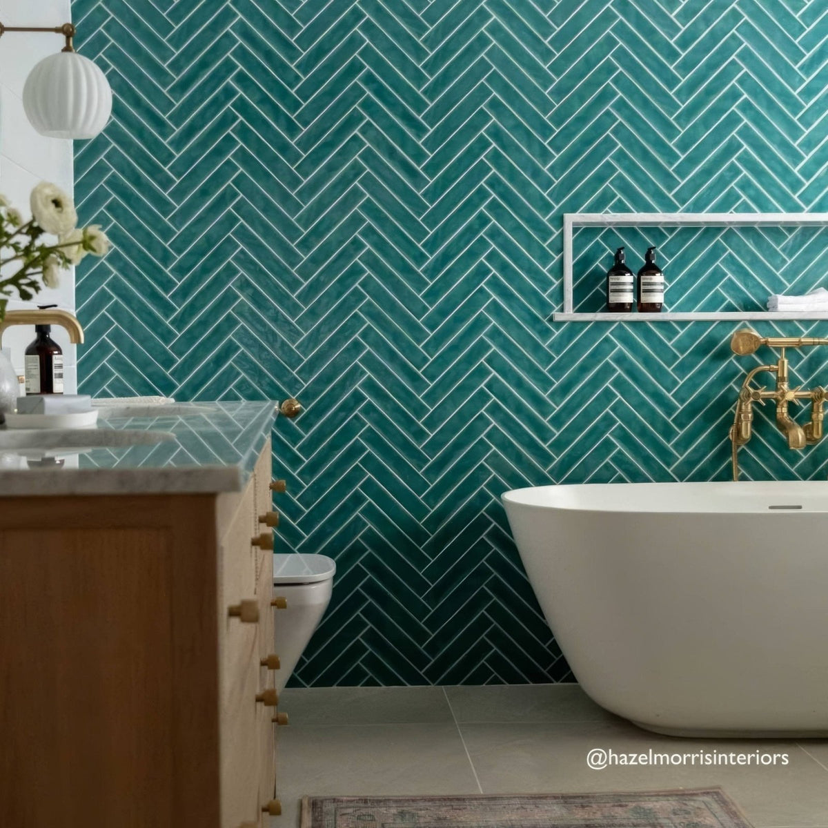 Teal herringbone patterned onda aquamarine wall tiles with white grout ideal for bathroom walls
