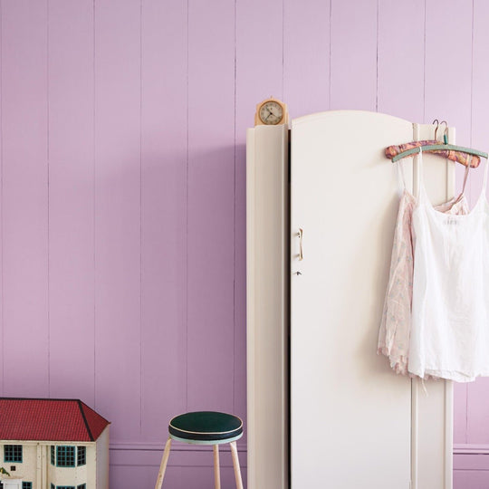 White wooden armoire with curved top and hanging garments from one october morning collection
