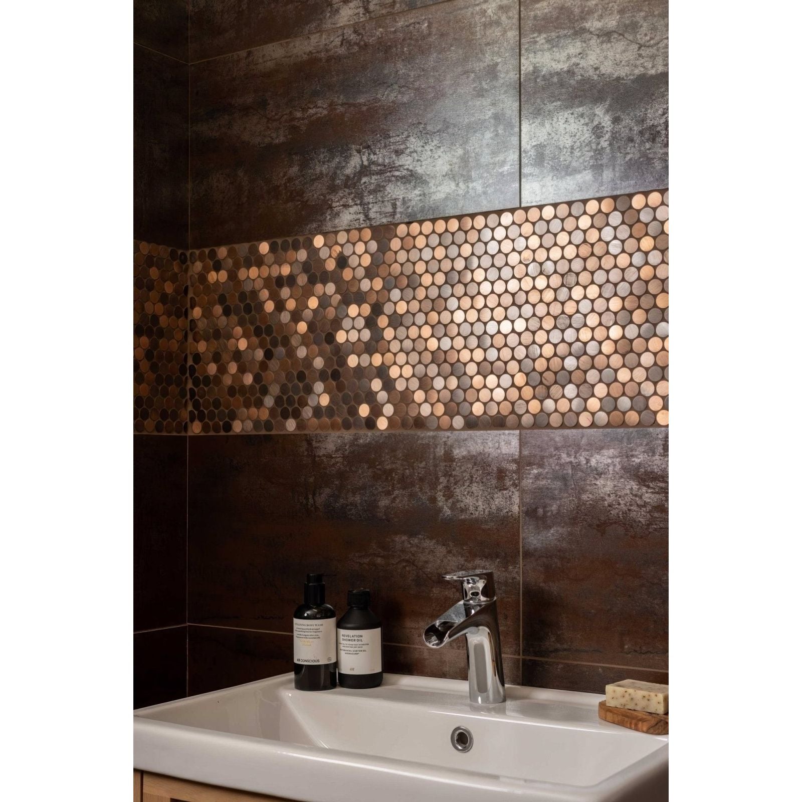 The orabella brushed metal mosaic features copper-toned hexagonal tiles on a dark textured bathroom wall panel