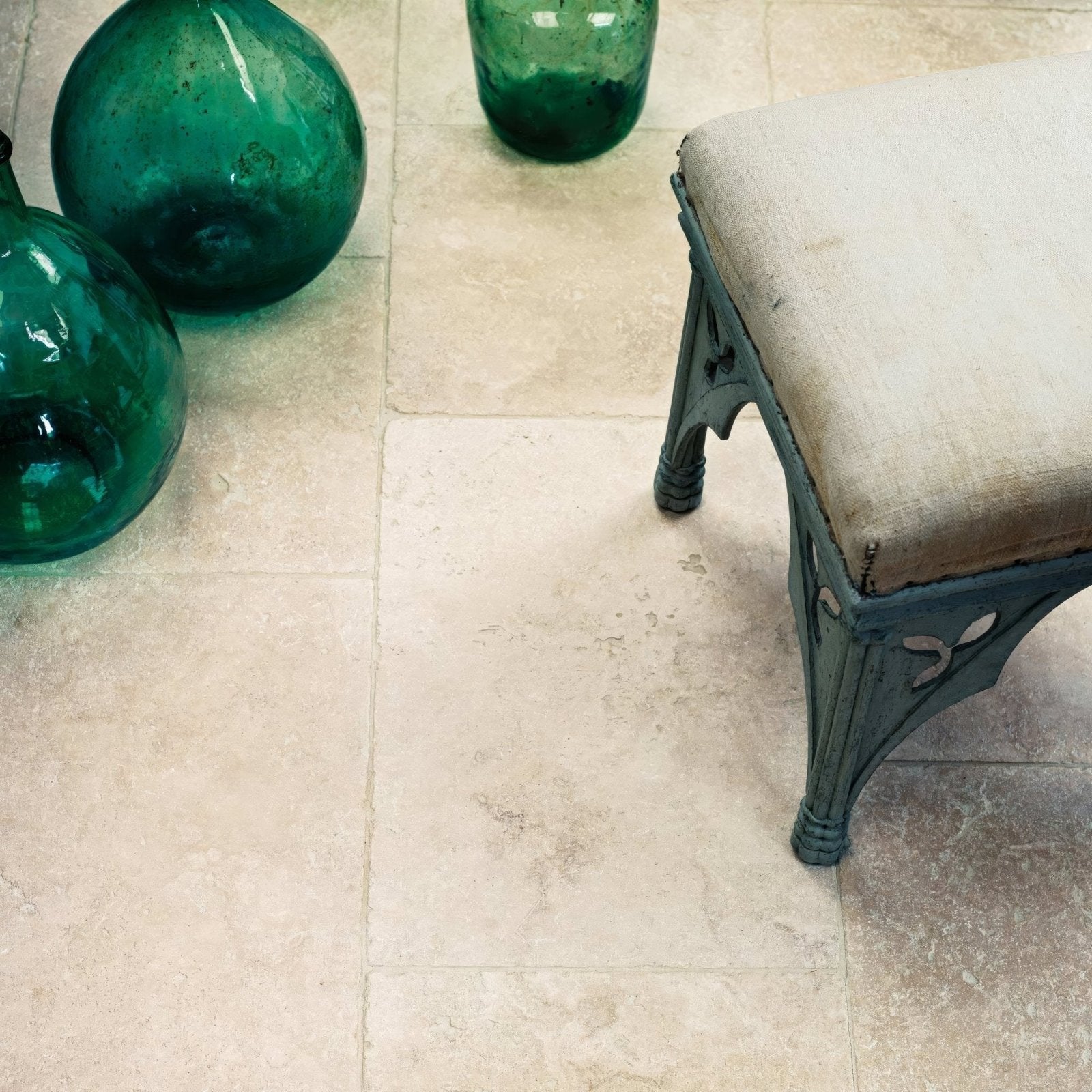 Orient 40x40 tumbled edge tile with dark green glossy glass vase featuring a rounded body and tapered neck
