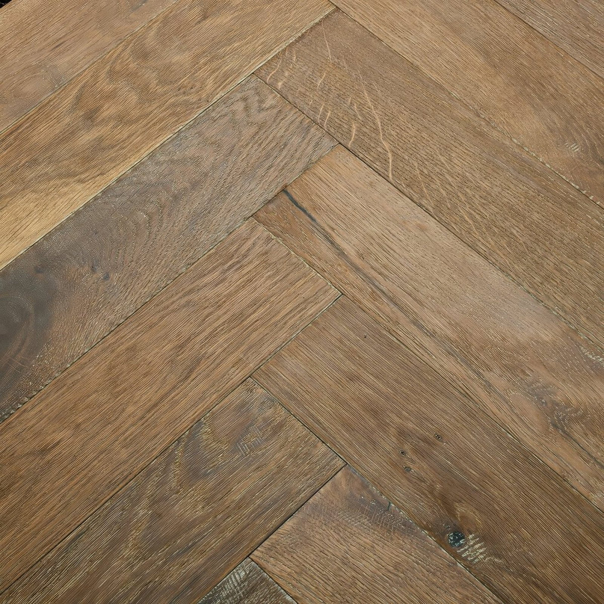 Warm-toned oak hardwood flooring in a classic herringbone pattern from orkney marbled oak collection