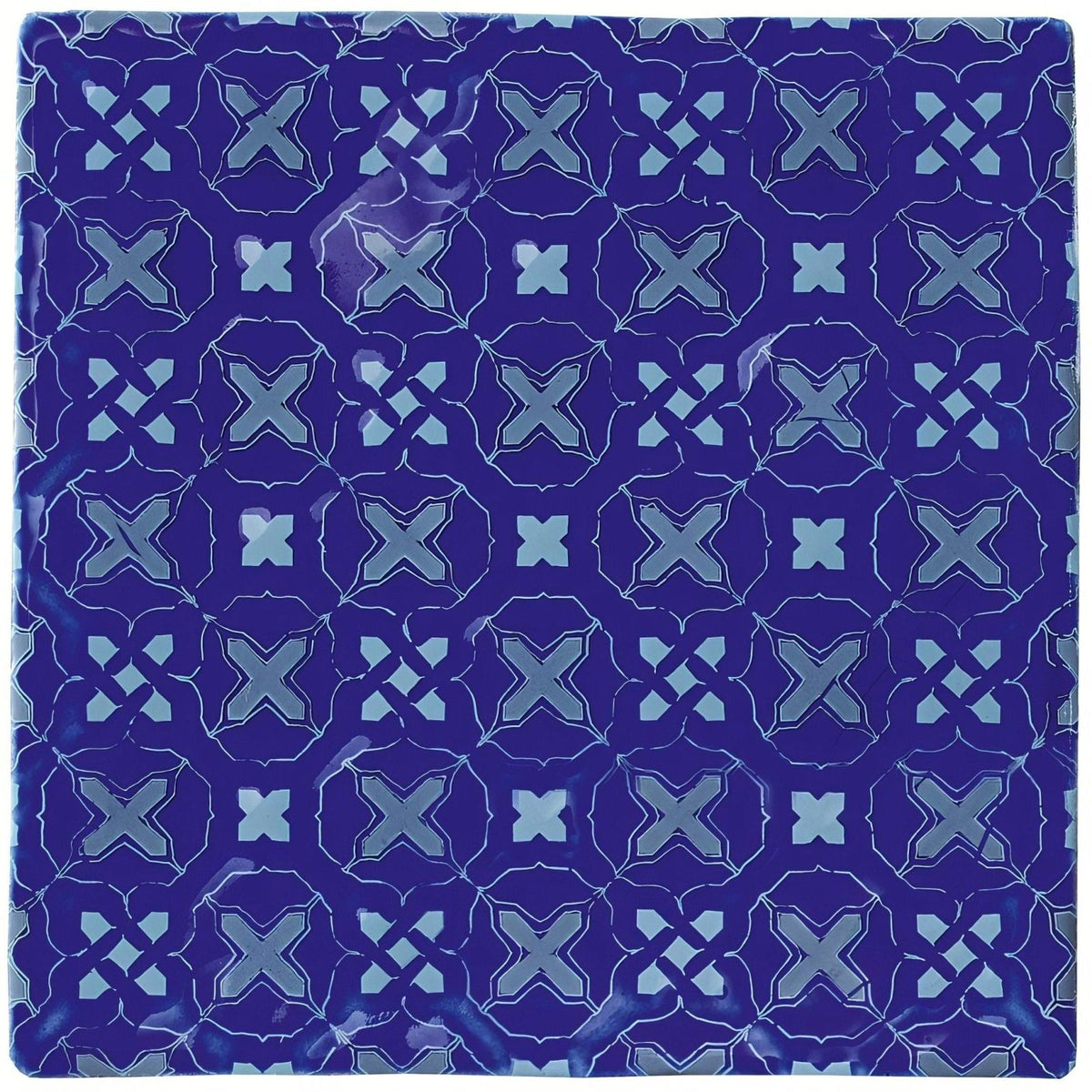 Deep blue ceramic tile ormeaux on amun with a repeating geometric pattern of lighter blue x-shapes and diamond accents