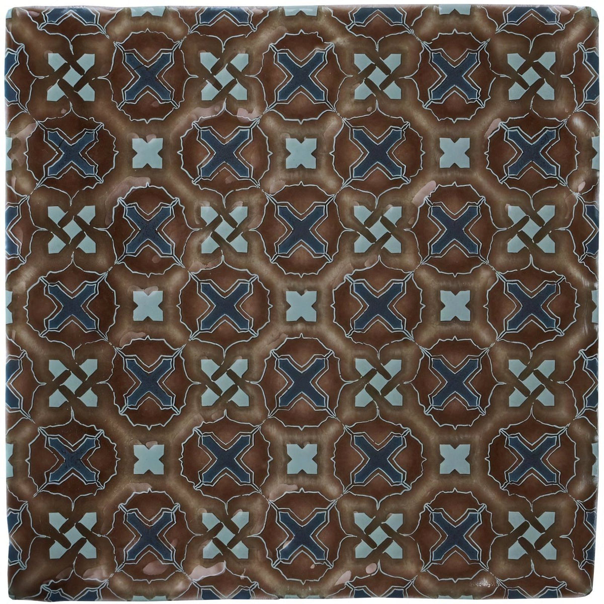 Brown ceramic tile ormeaux on chestnut with navy blue and light teal geometric cross pattern on textured earthy background