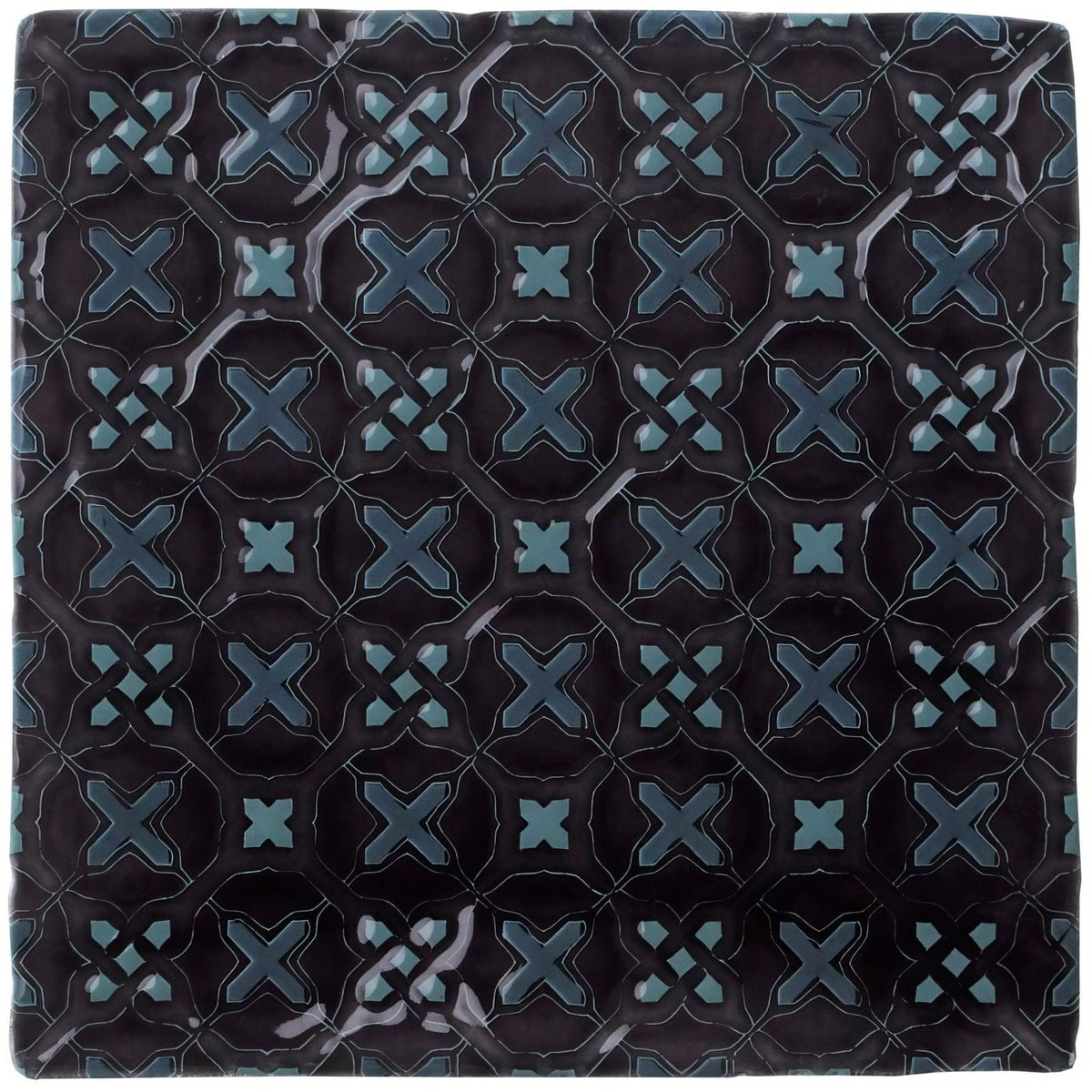 Dark blue ceramic tile ormeaux on sloe with glossy finish and intricate teal geometric x-shape pattern