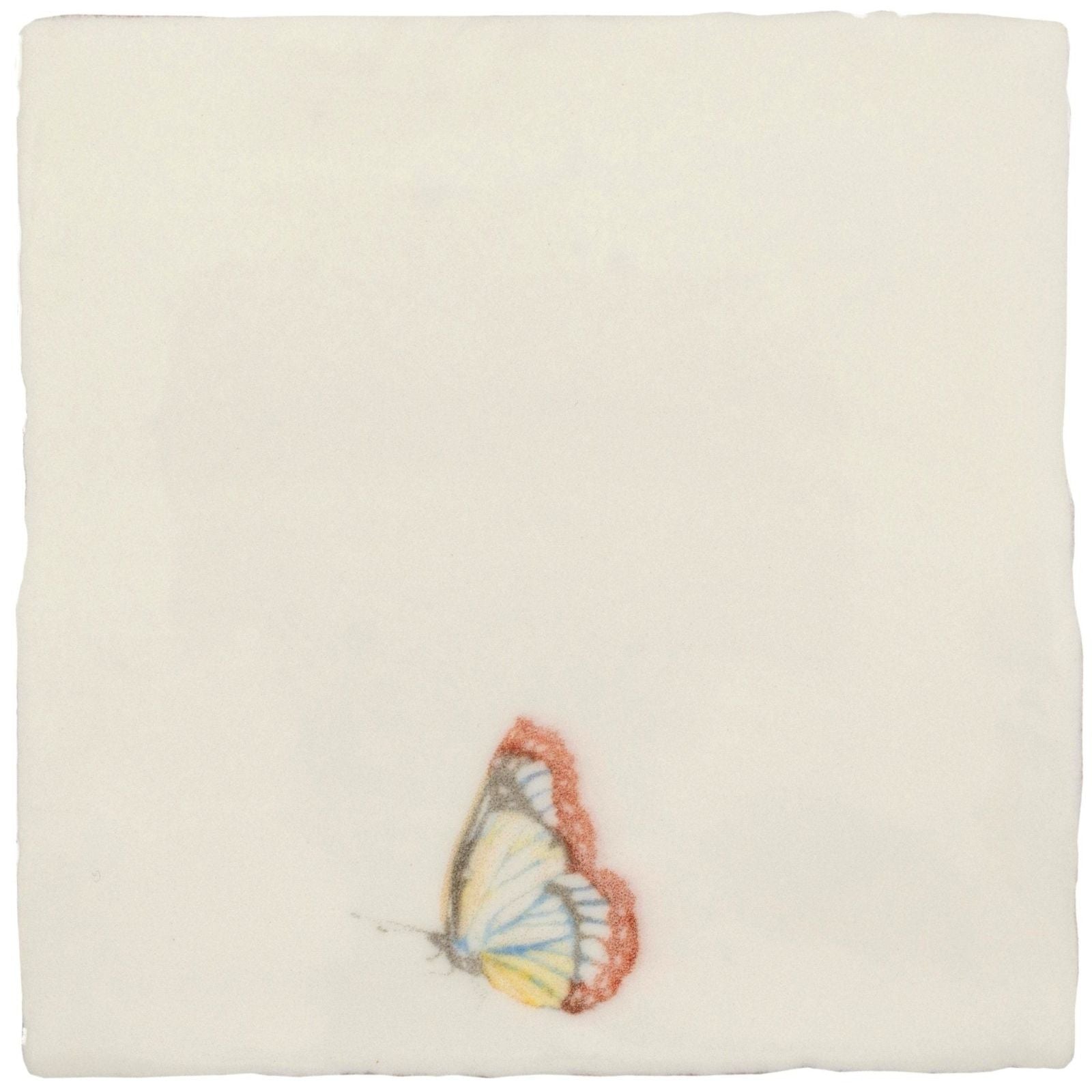 A delicate hand-painted butterfly with translucent soft yellow and white wings rests on a pastel cotton ceramic tile