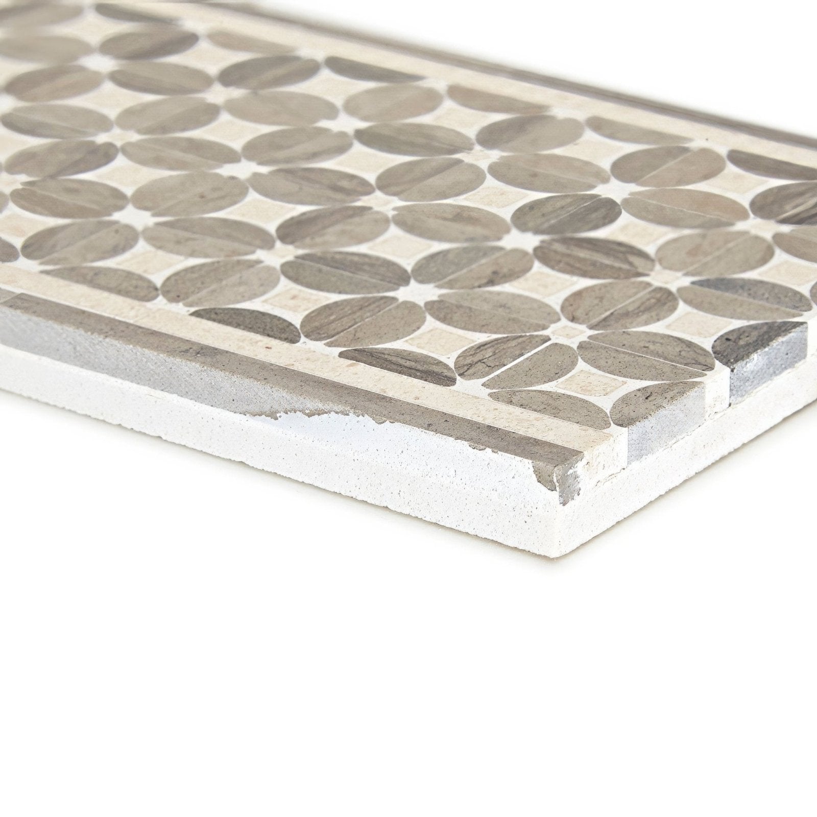 Gray circular mosaic tile with textured stone finish and white mortar border from palazzo mancini border collection