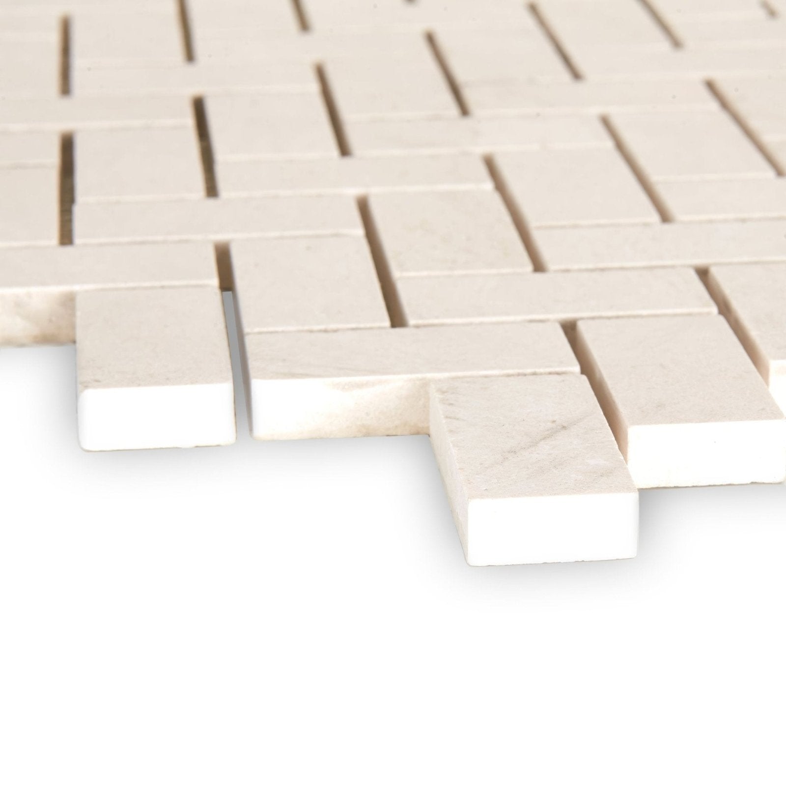 Palio limestone herringbone mosaic tile in cream-colored marble with subtle veining in an interlocking woven design