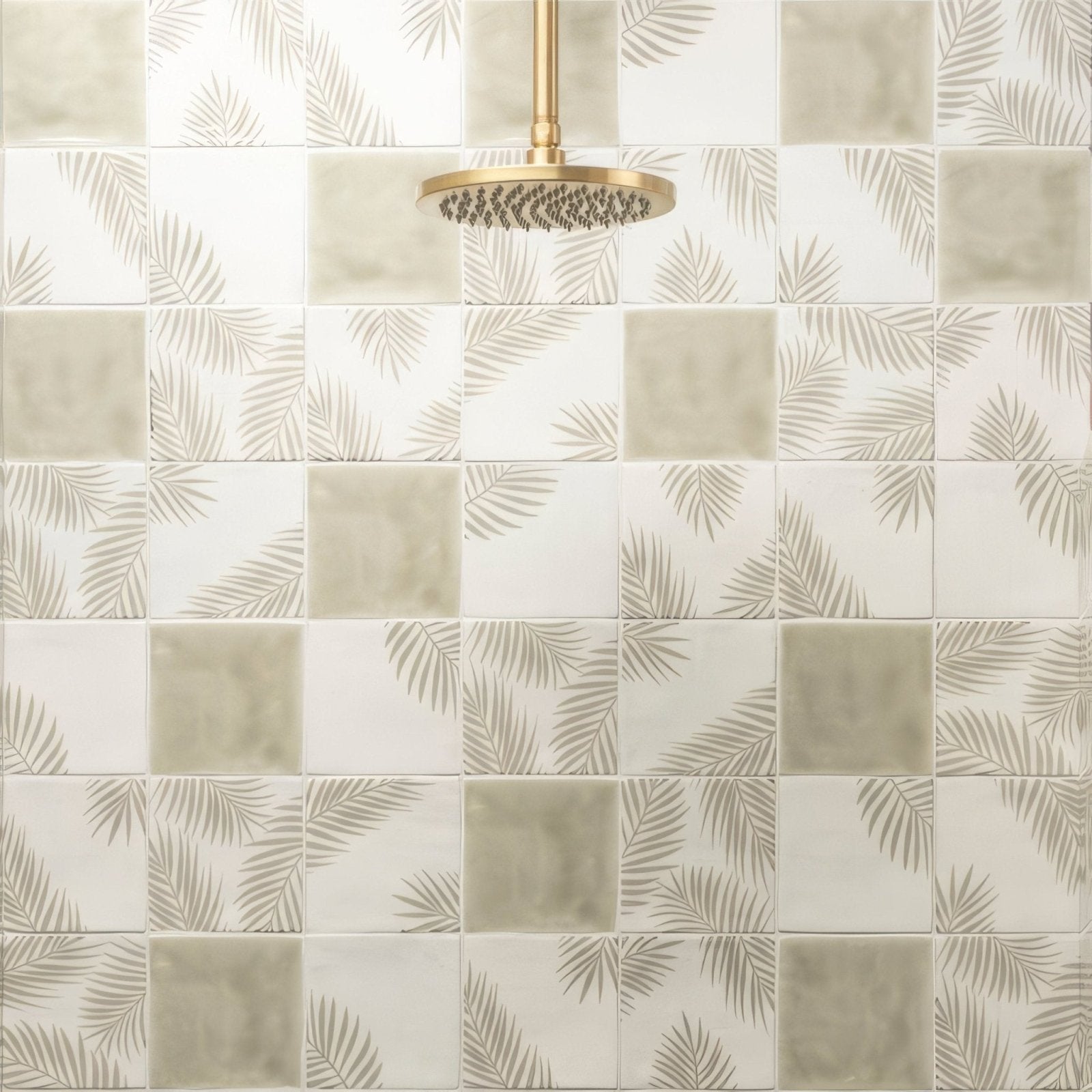 Gold-toned paradisl mere 1 showerhead with circular textured spray face mounted above tiled wall