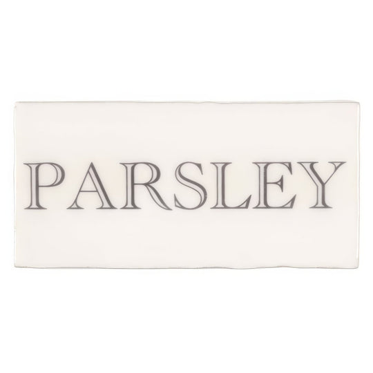 Cream-colored rectangular ceramic tile with the word parsley in dark gray serif font from Parsley in Grey on Cotton
