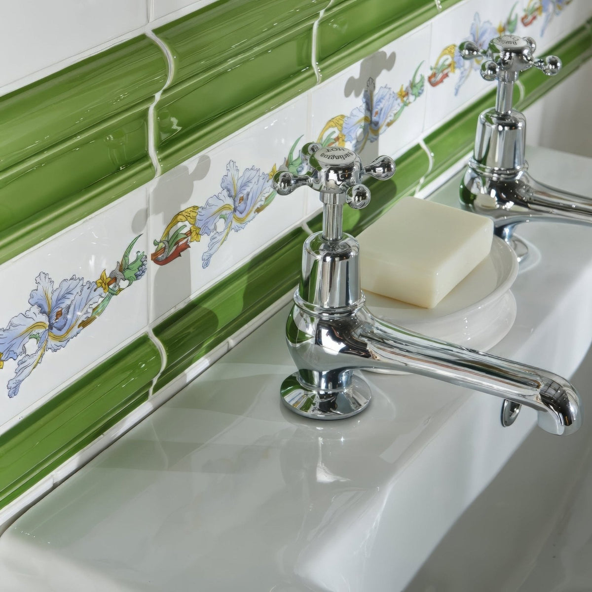 Chrome-finished cross-handle bathroom faucet with polished reflective surface from pavilion green albert moulding collection