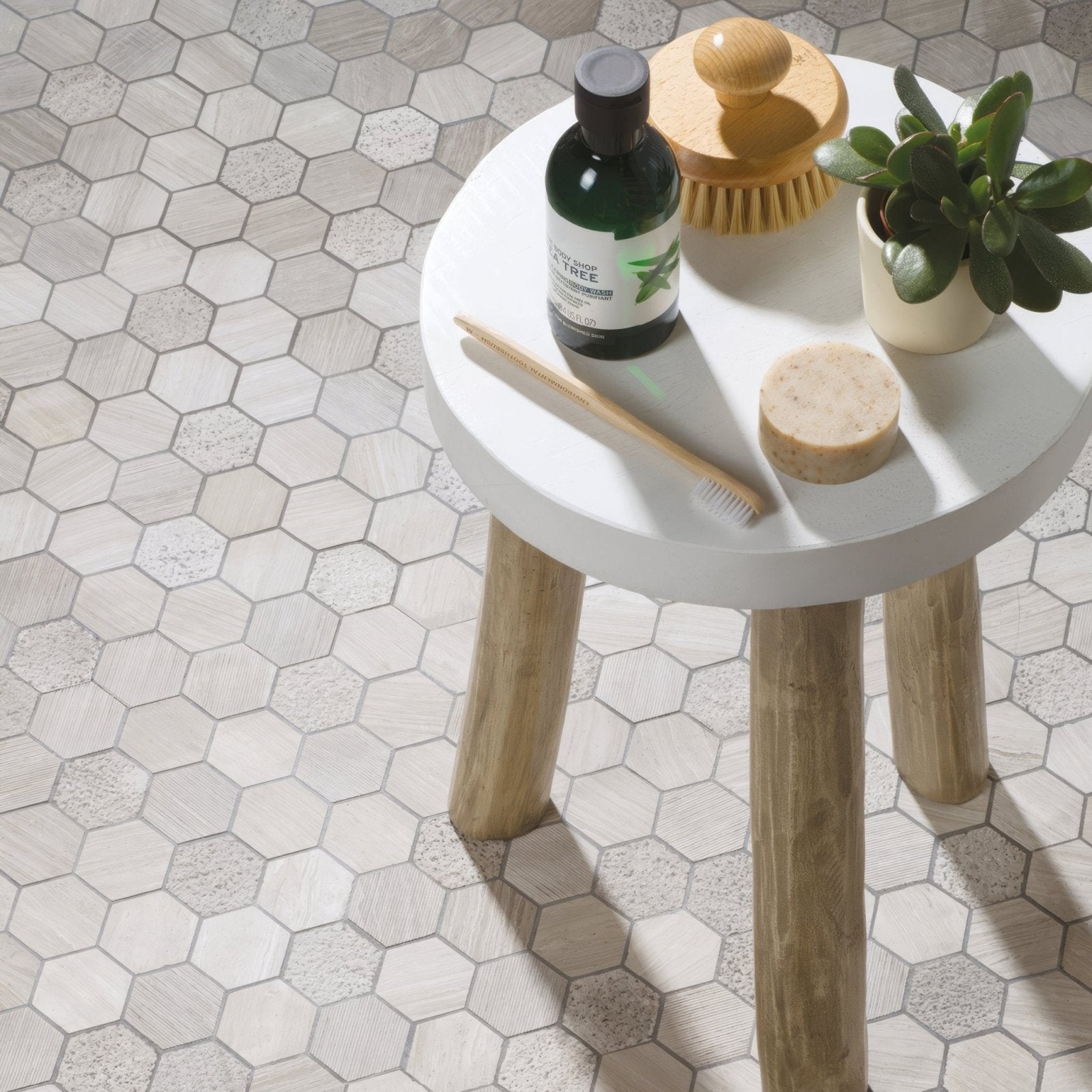 White round table with wooden legs featuring a perla large hexagon stone mosaic top for stylish decor