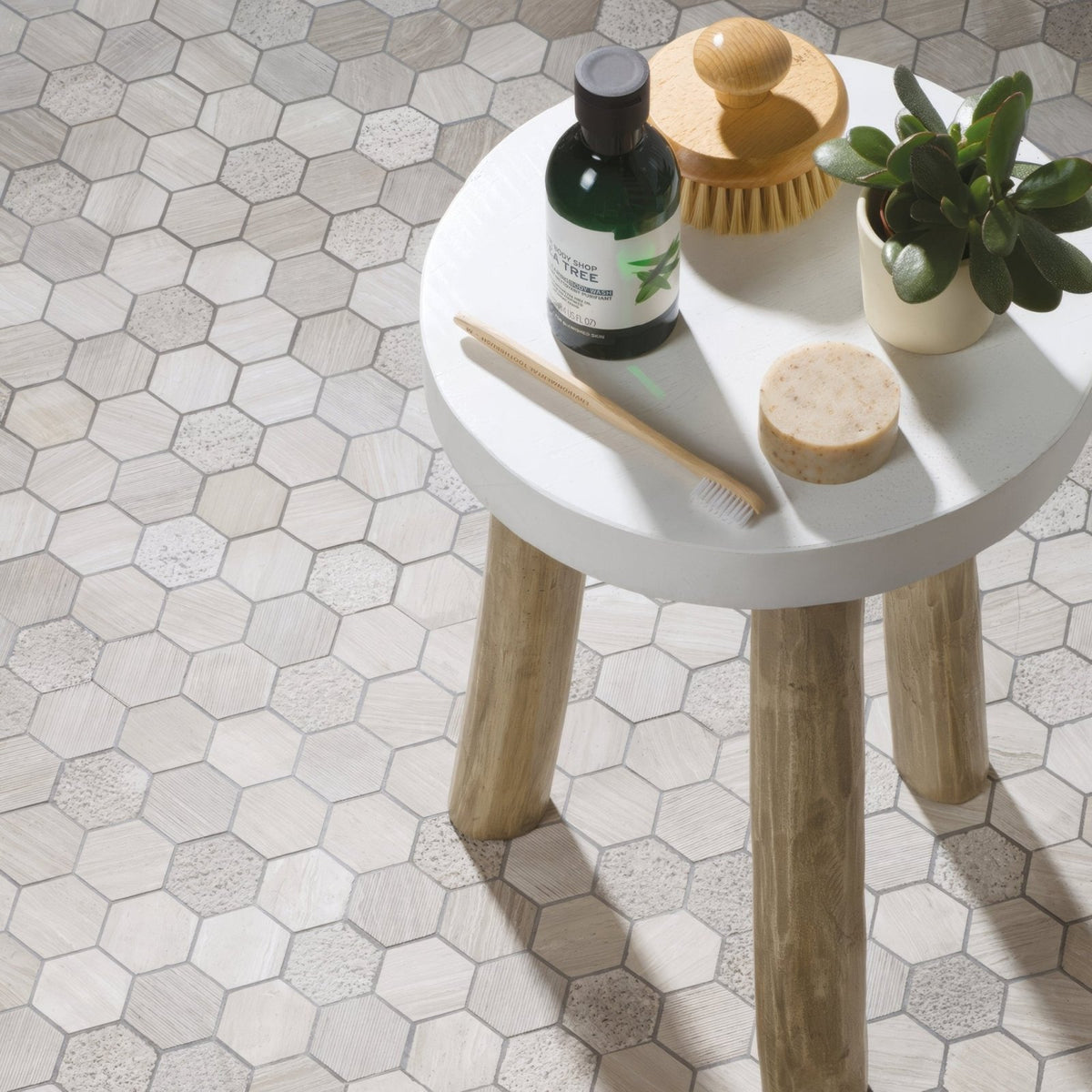 Perla Large Hexagon Stone Mosaic grey and beige hexagonal stone mosaic on a round wooden-legged table