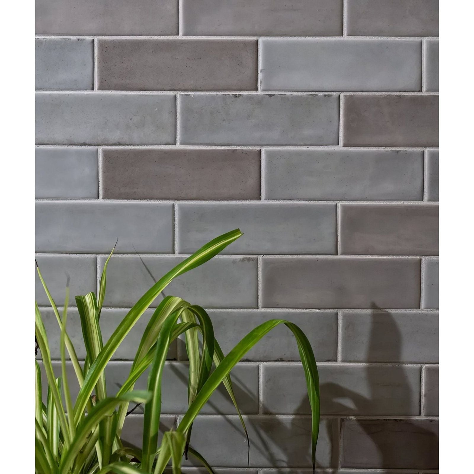 Gray rectangular subway tiles arranged in a classic brick pattern petite porcelain gloss pearl finish