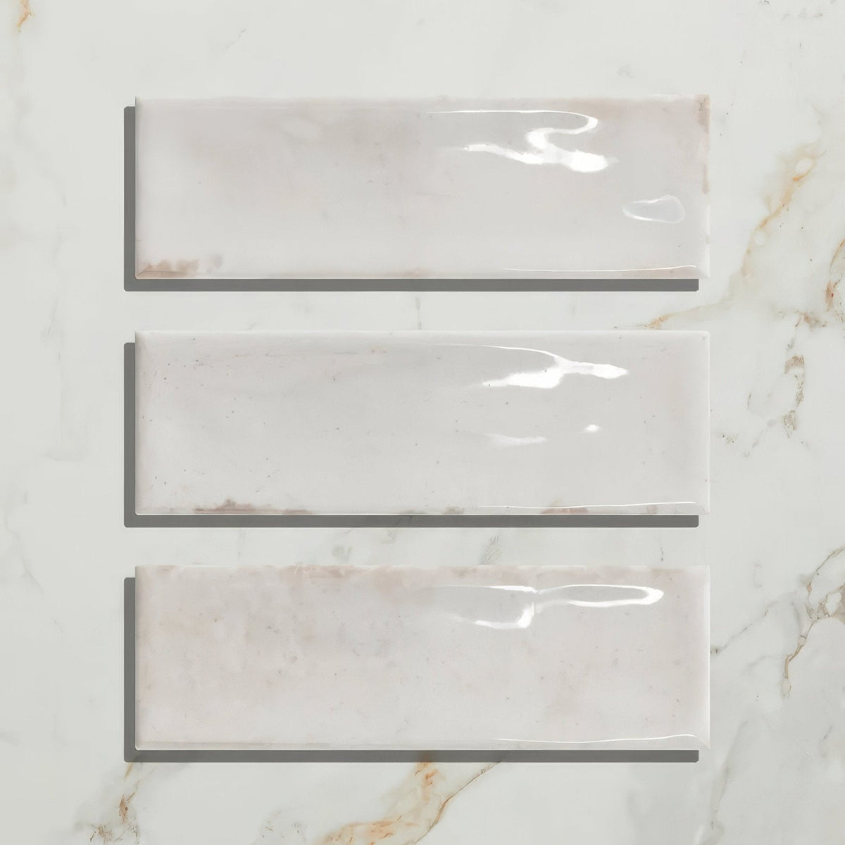 Three rectangular petite porcelain gloss white ceramic tiles with subtle beige veining arranged vertically