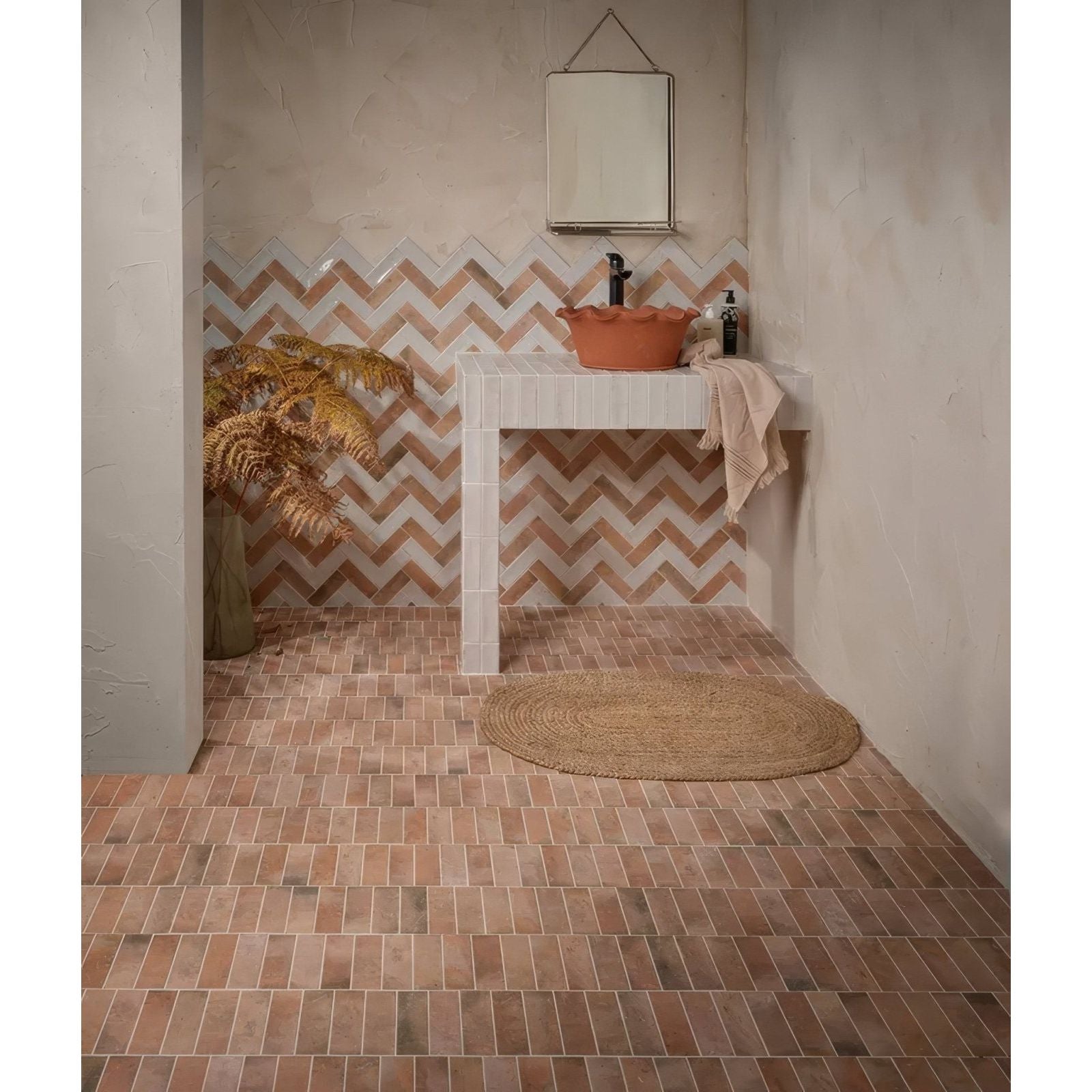 Terracotta-colored petite porcelain matt cotto dark rectangular tiles arranged in a herringbone pattern on wall and floor