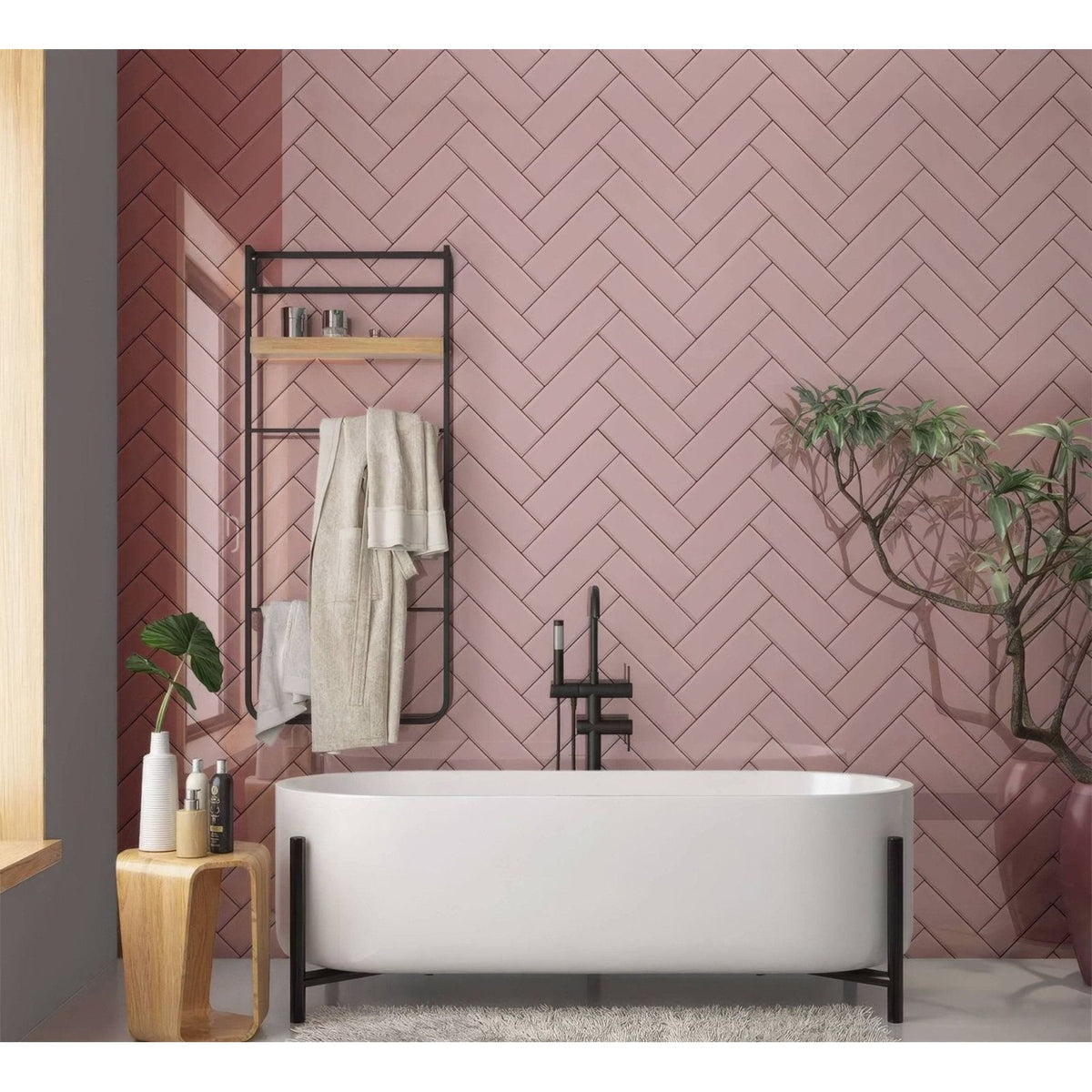Modern freestanding bathtub with sleek white ceramic finish and minimalist black metal legs for a pink herringbone shower panel
