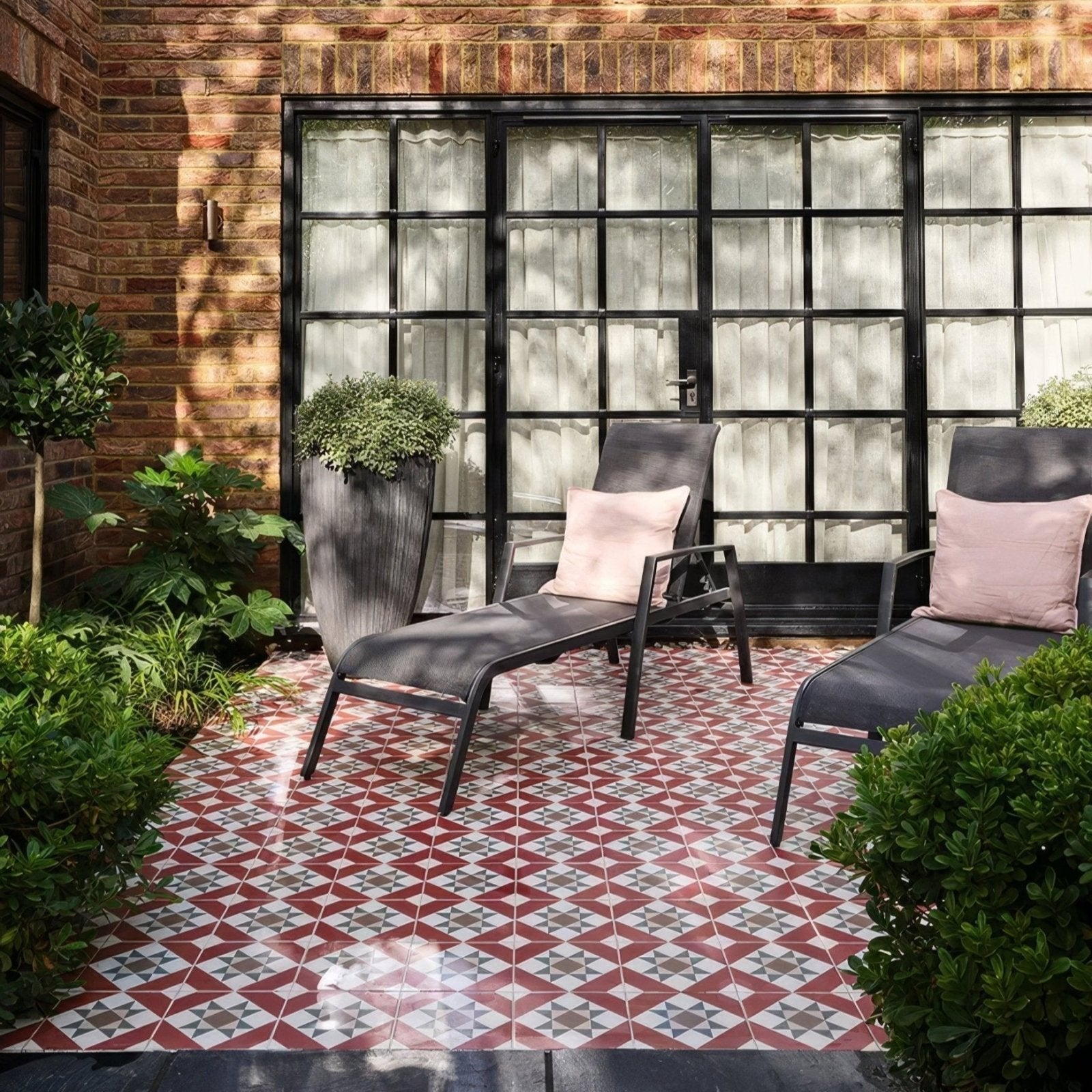 Two brompton porcelain clarence lounge chairs with black metal frames dark gray fabric and pink cushions