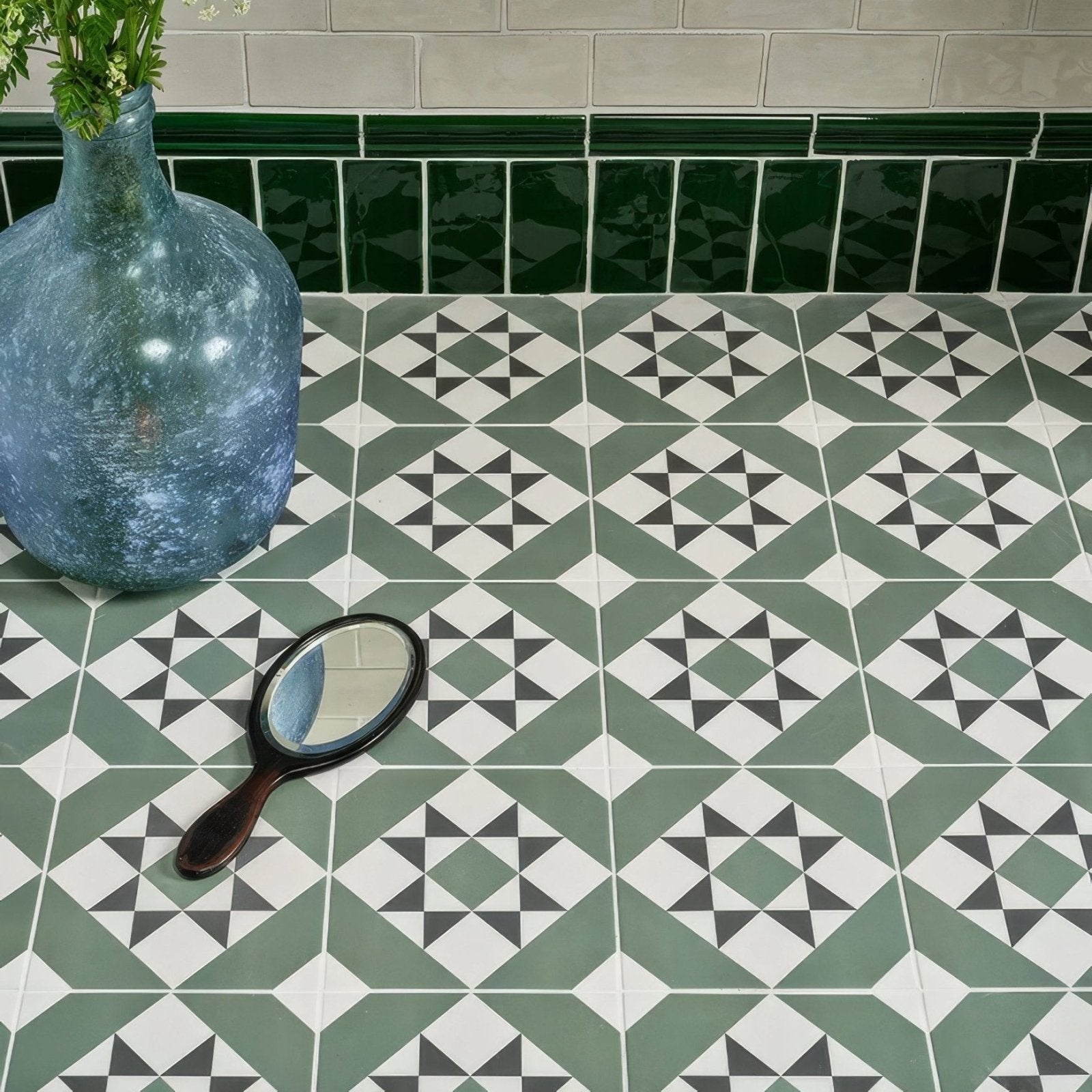 A brompton porcelain greenwich vintage-style hand mirror with a dark wooden handle and oval reflective surface