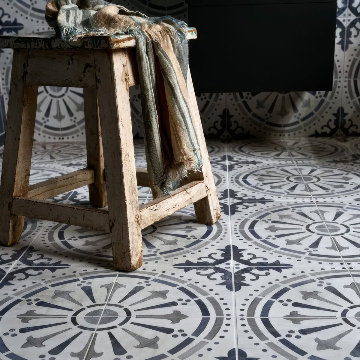 Weathered wooden stool with faded white paint finish and rustic chipped edges from canero ceramic matt collection