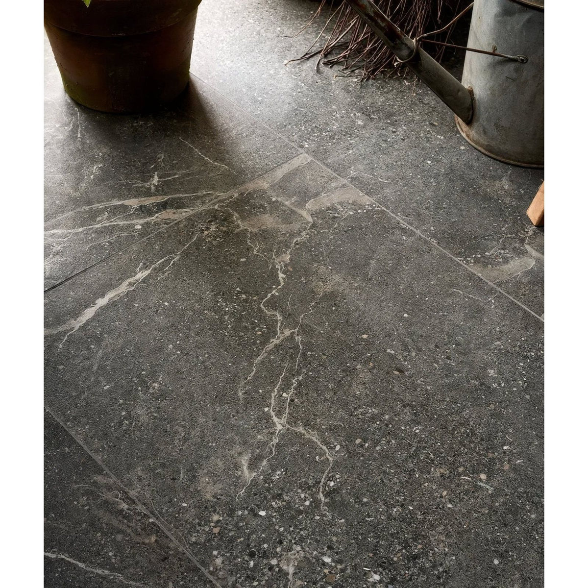 Etna porcelain matt tile 59.5x59.5cm in dark gray stone with subtle white veining and speckled texture