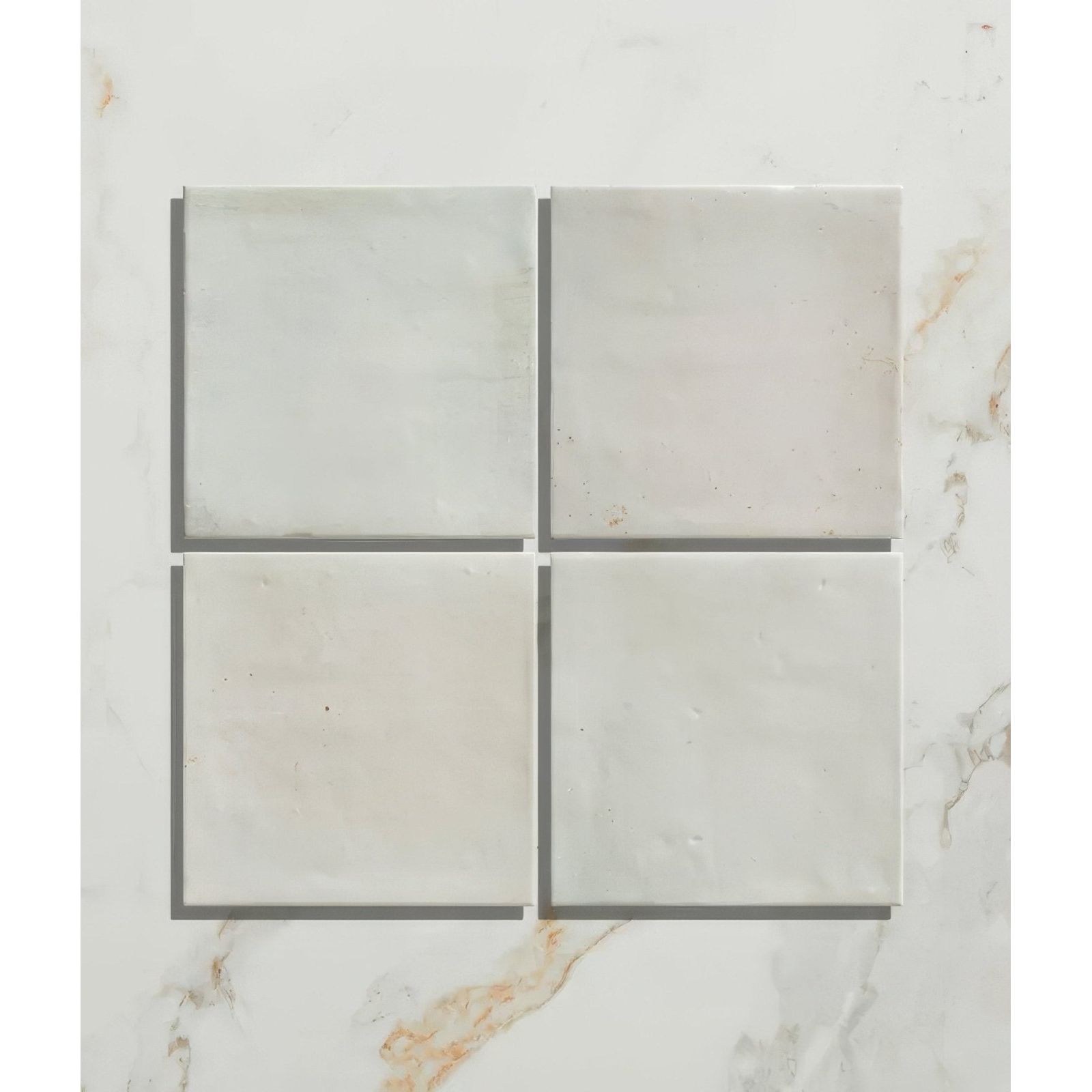 Four light gray marble ceramic tiles with subtle veining arranged in a grid for hammam ceramic blue collection