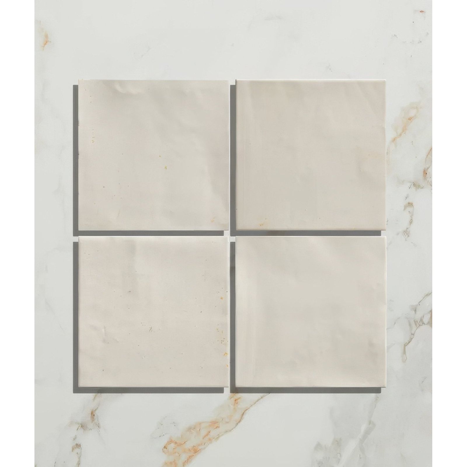 Four square off-white marble hammam ceramic white tiles with subtle veining arranged in a grid pattern