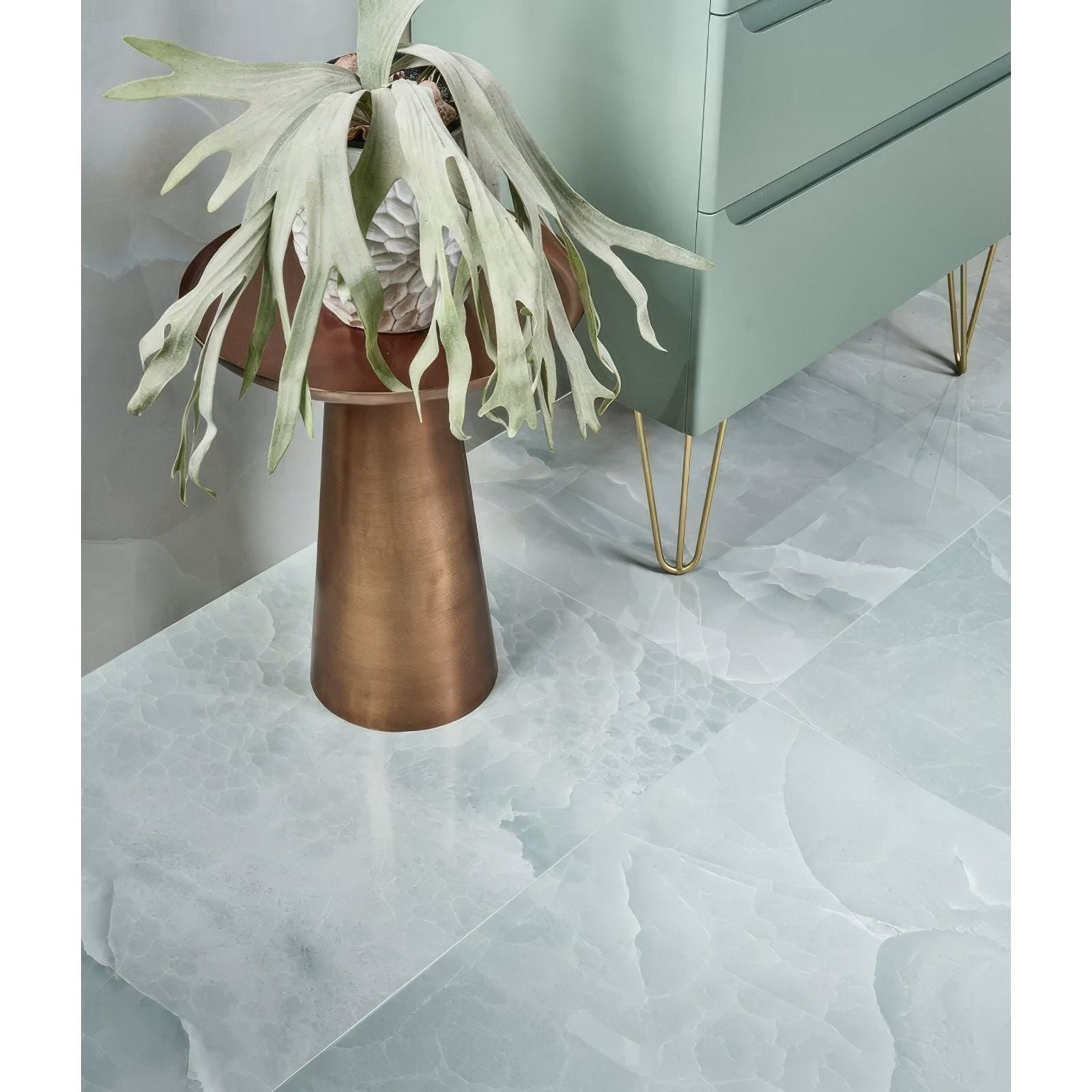 Bronze conical pedestal with staghorn fern in textured white pot on polished lagoon illusion whisper onyx porcelain surface