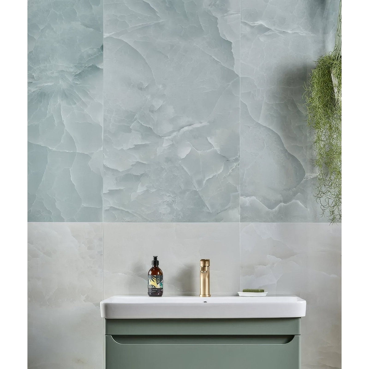 illusion Whisper Onyx Porcelain Polished Lagoon pale green marble-effect tiles with a sink and sage green vanity
