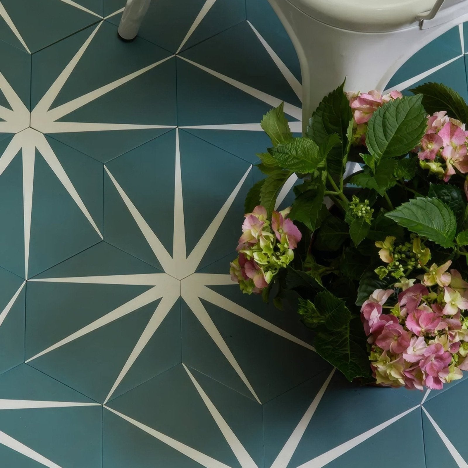 A bouquet of pink and green hydrangeas with lush foliage in lily pad porcelain eucalyptus arrangement