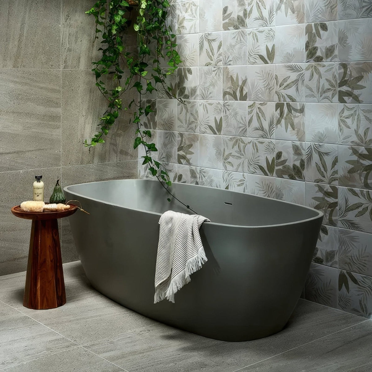 Modern matte gray freestanding bathtub with sleek oval design and towel draped over edge in pembroke porcelain satin finish