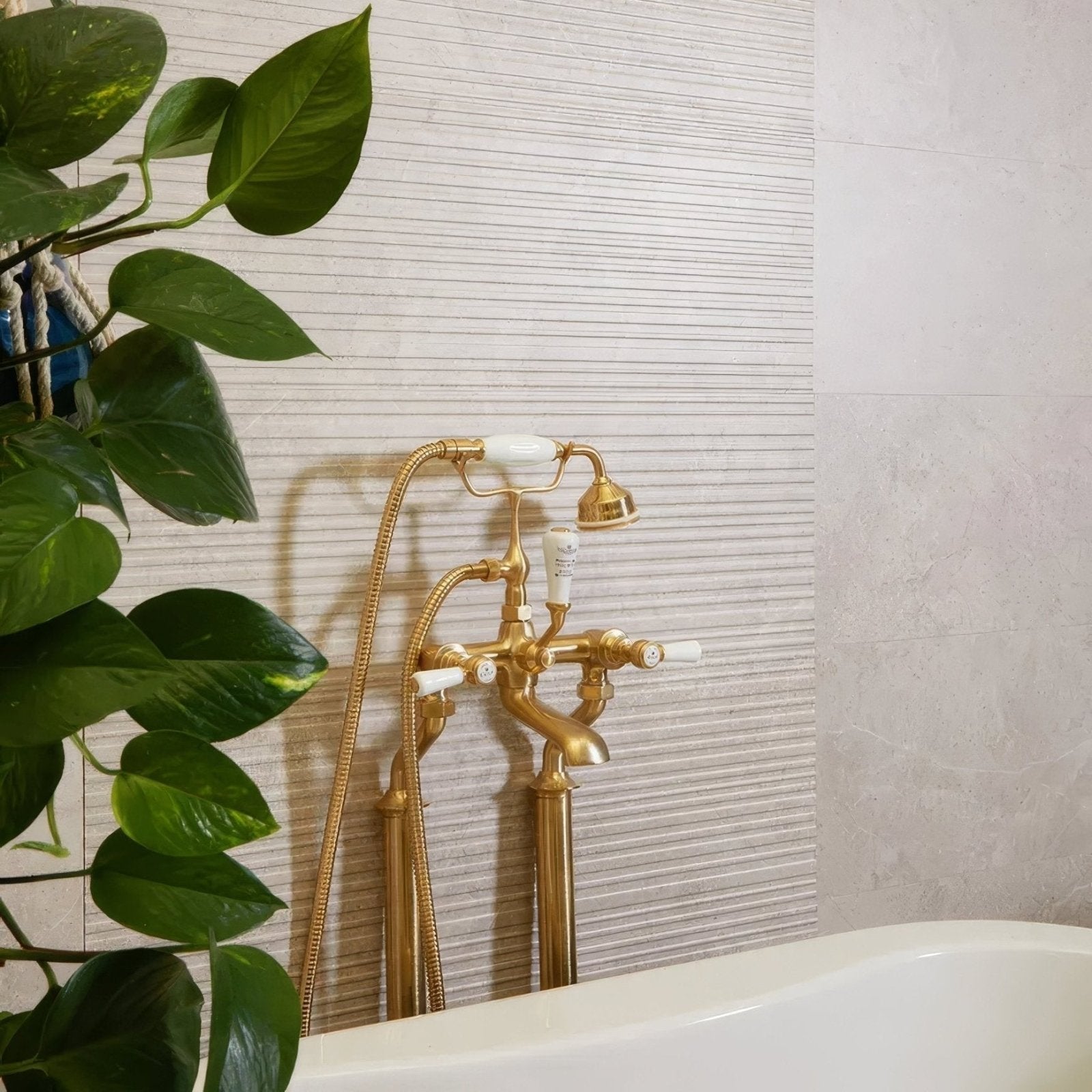 Riverside Wall Ceramic Linear Perla white ceramic tiles with a gold bathtub tap and showerhead