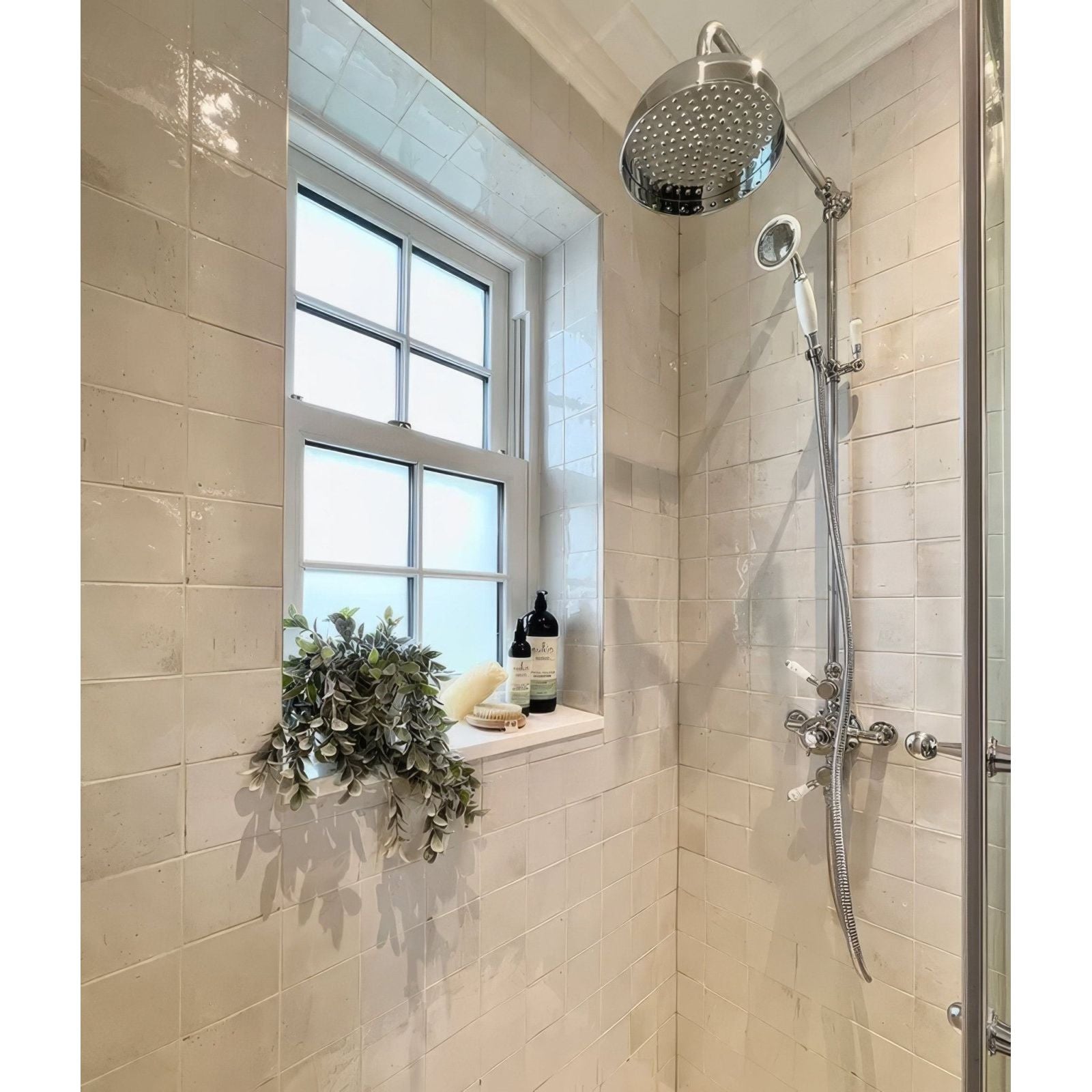 Stainless steel showerhead with sleek rounded design and perforated surface for natural cotton square use