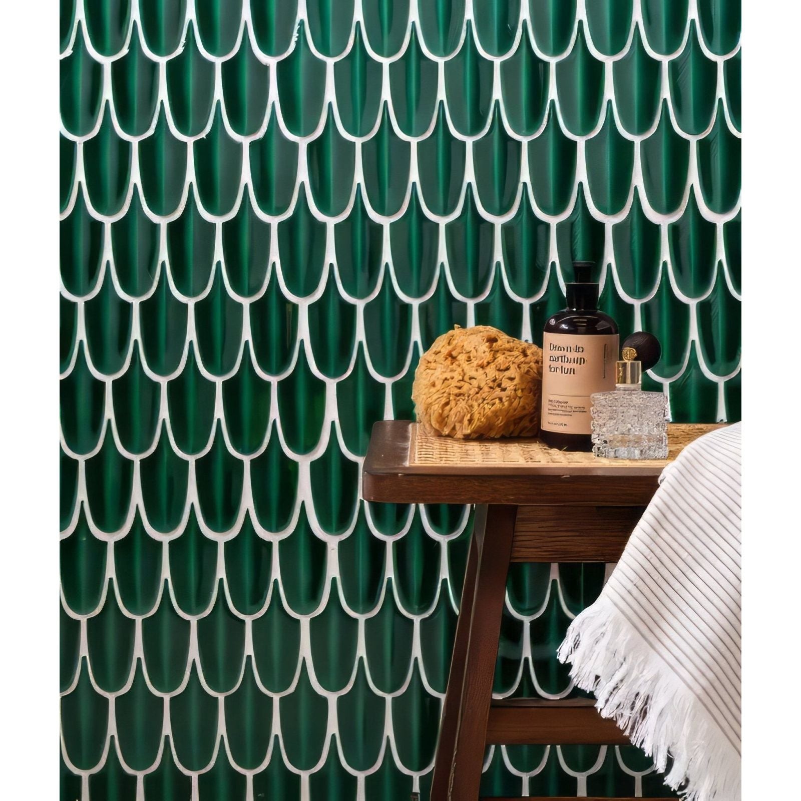 Deep emerald green porcelain fish-scale mosaic tiles with white grout lines create textured wall backdrop