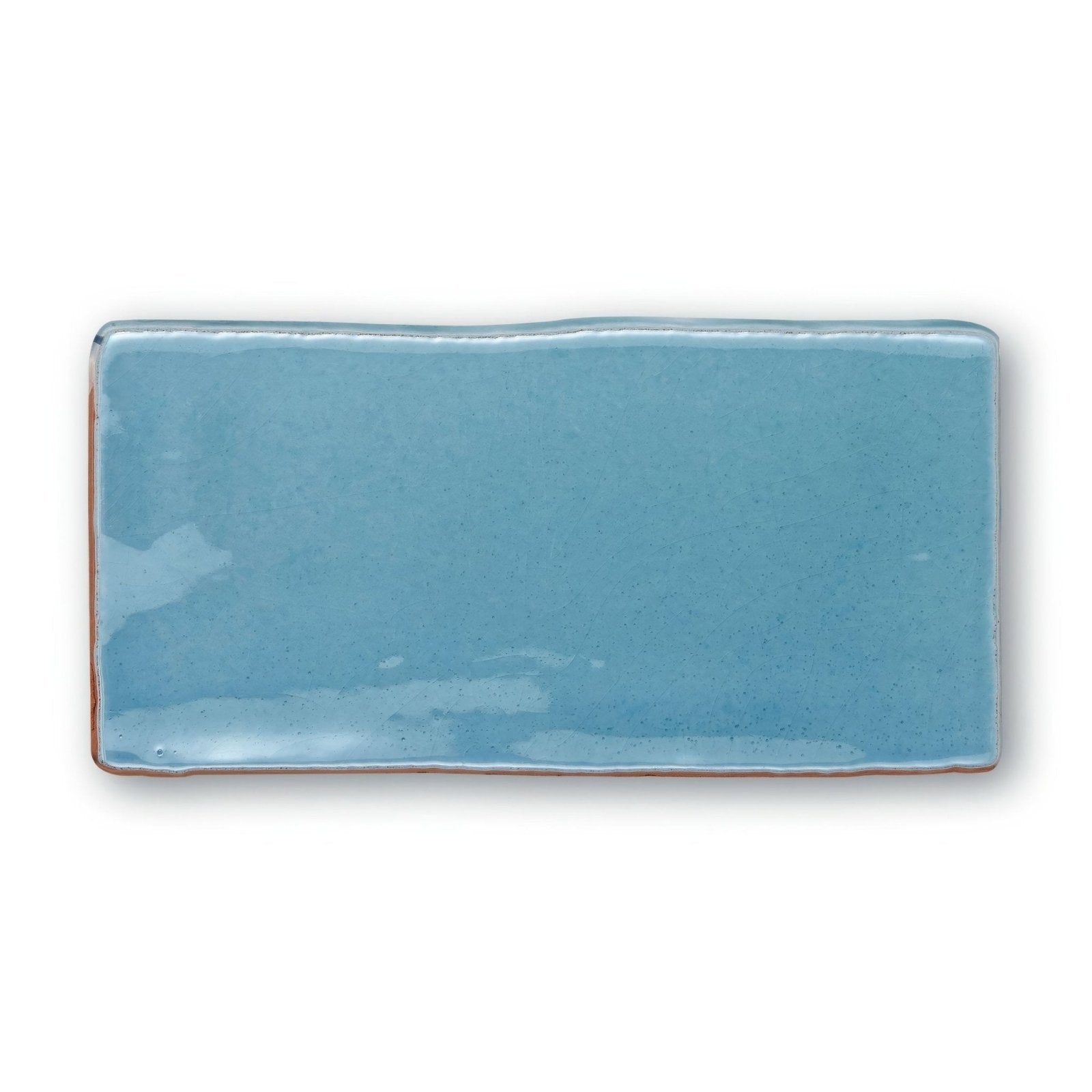 A rectangular ceramic tile with a glossy light blue glaze and slightly uneven edges from Provence Turbie Rectangle collection
