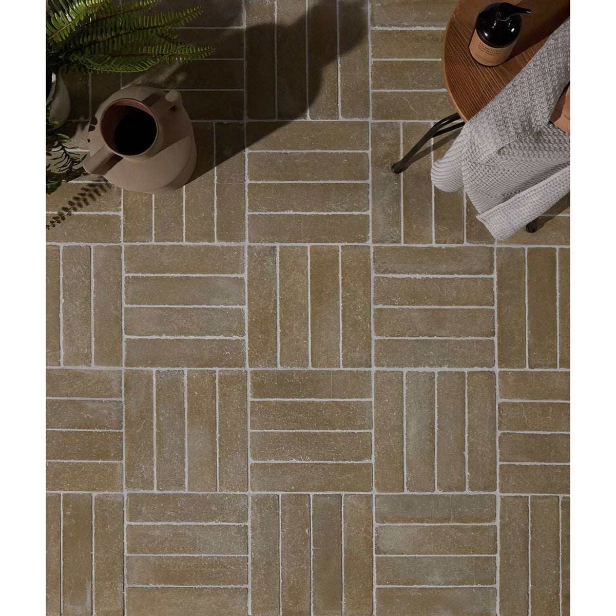 Beige rectangular reform composite stone tumbled khaki tiles with subtle texture in interlocking herringbone pattern
