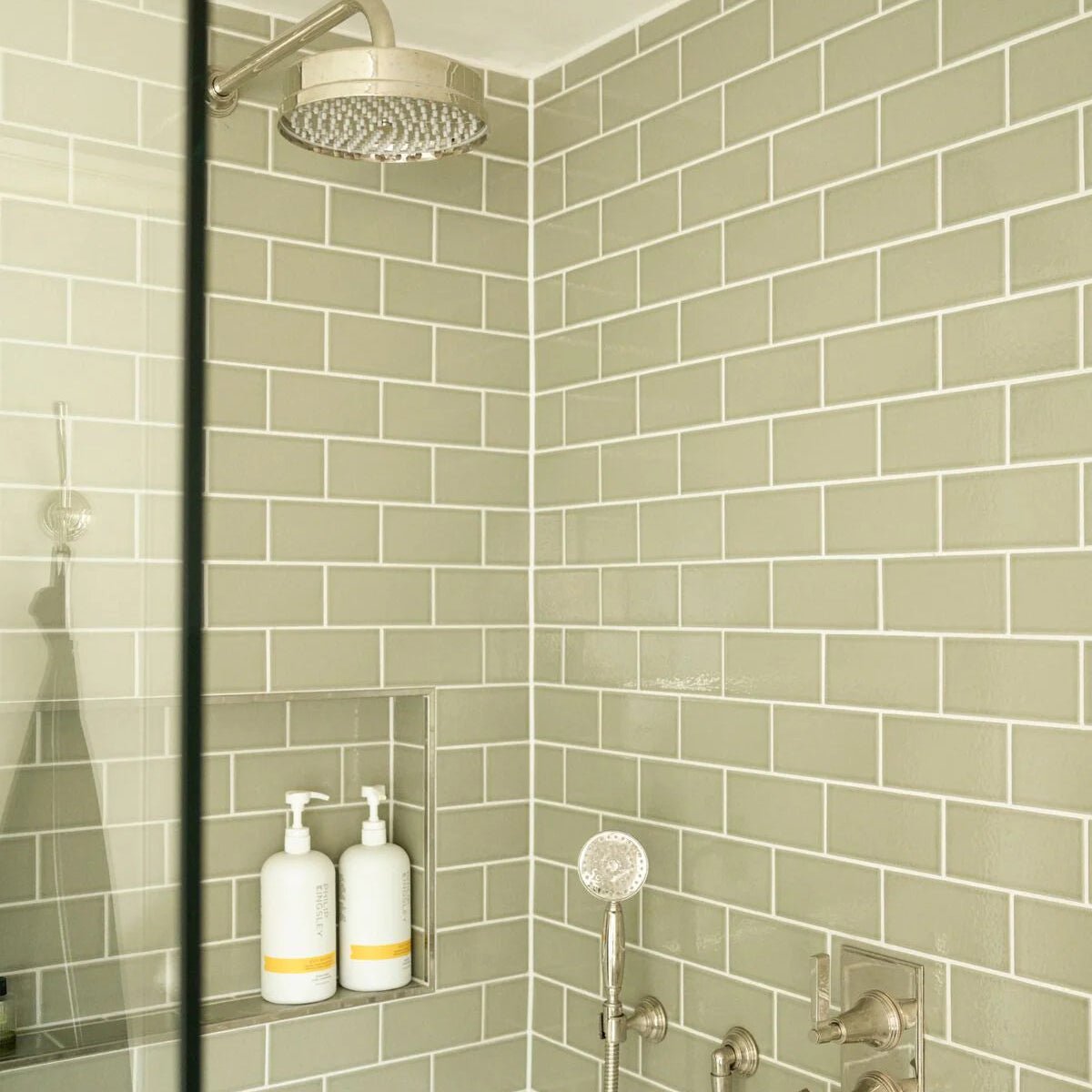 Retro Metro Gloucester Road 7.5 x 15 Glazed Tile sage green glazed tiles with a chrome showerhead