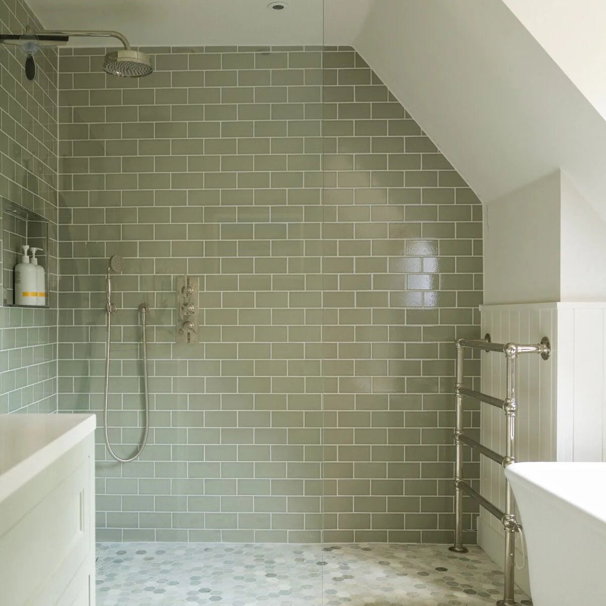 The bathroom wall is covered in retro metro gloucester road 7.5 x 15 sage green glazed subway tiles in a brick pattern