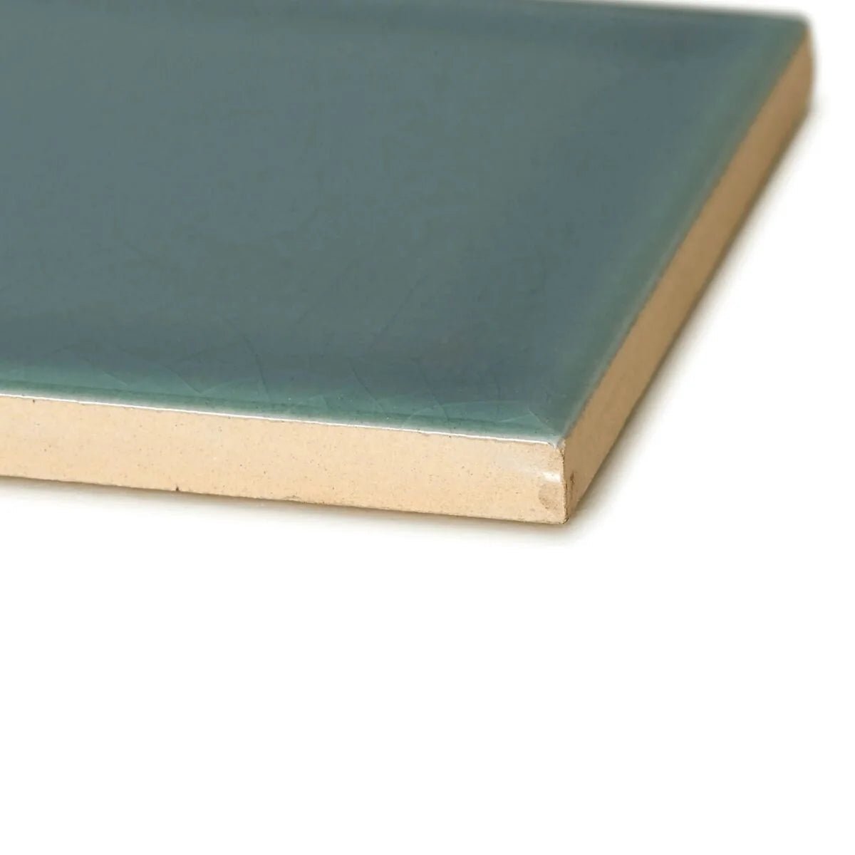 A square ceramic retro metro green park tile with smooth matte teal glaze and unglazed beige edge 7.5 x 15