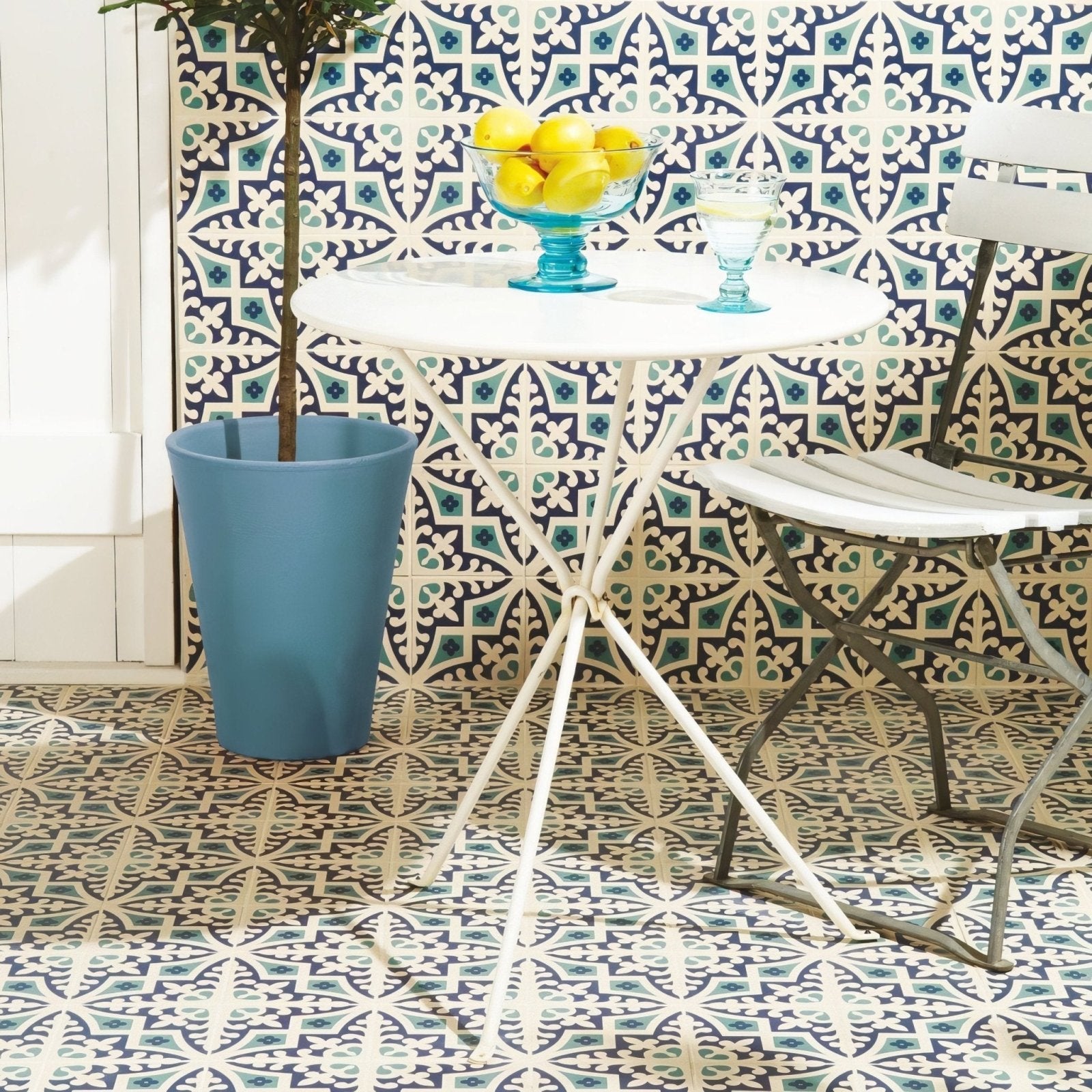 White metal folding table with round top and tripod legs featuring Romanesque dark blue and dark jade on white
