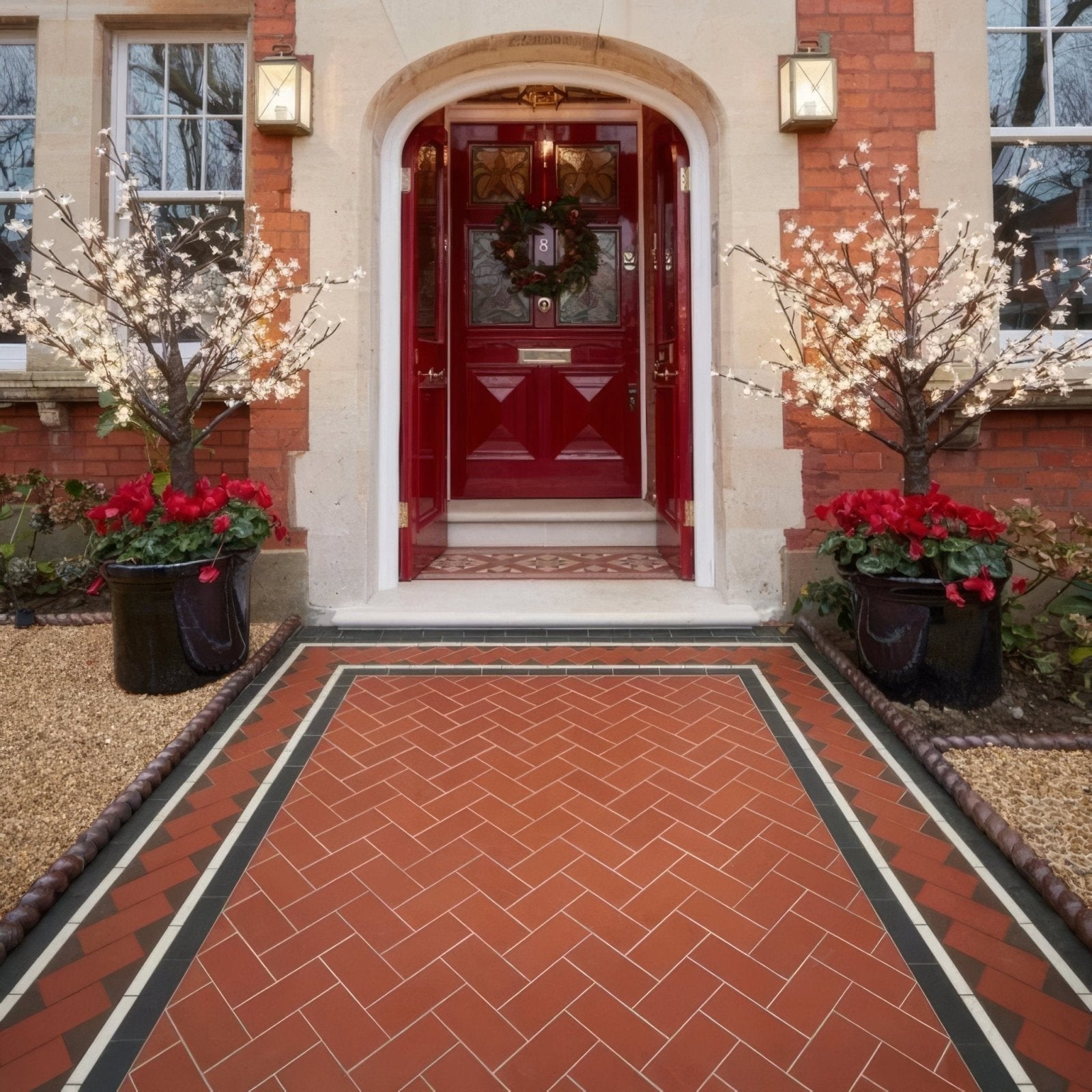 A vibrant scarborough red paneled front door with glass panels and a decorative wreath