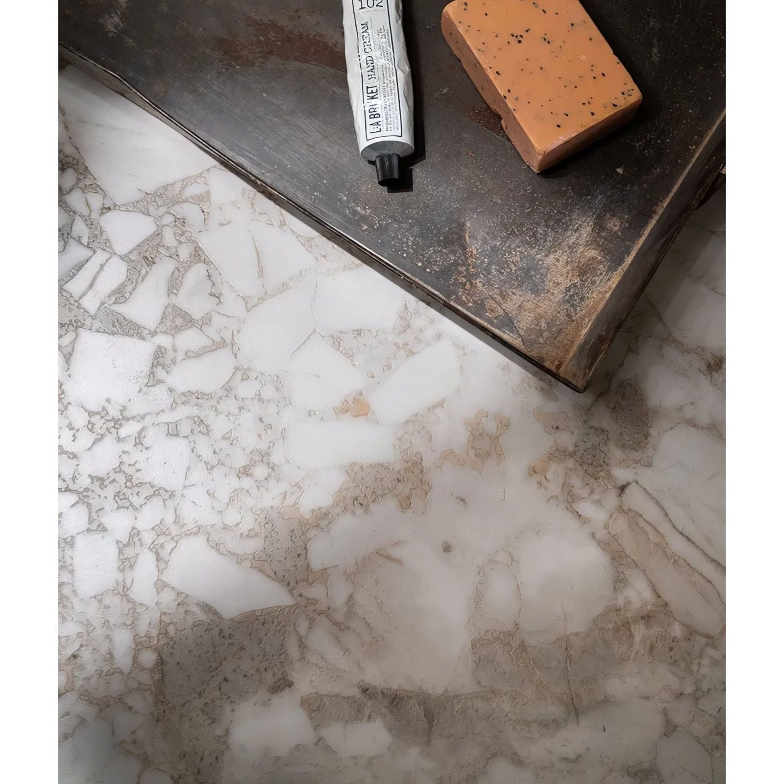 Sculpture Grande Porcelain Ceppo grey terrazzo-effect tiles with hand cream and soap