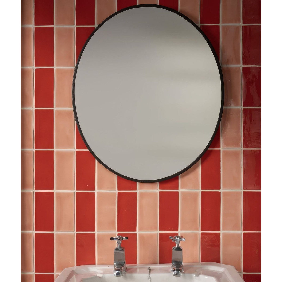Circular mirror with a sleek black frame mounted above a sink complementing Seaton ceramic marmalade design