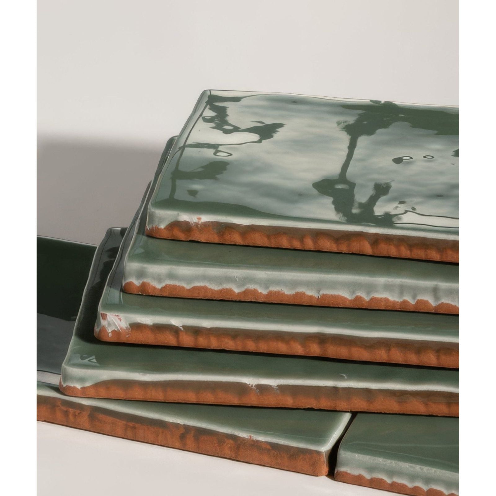 Stacked rectangular seaton ceramic sea cabbage tiles with glossy sage green glaze and rustic terracotta edges